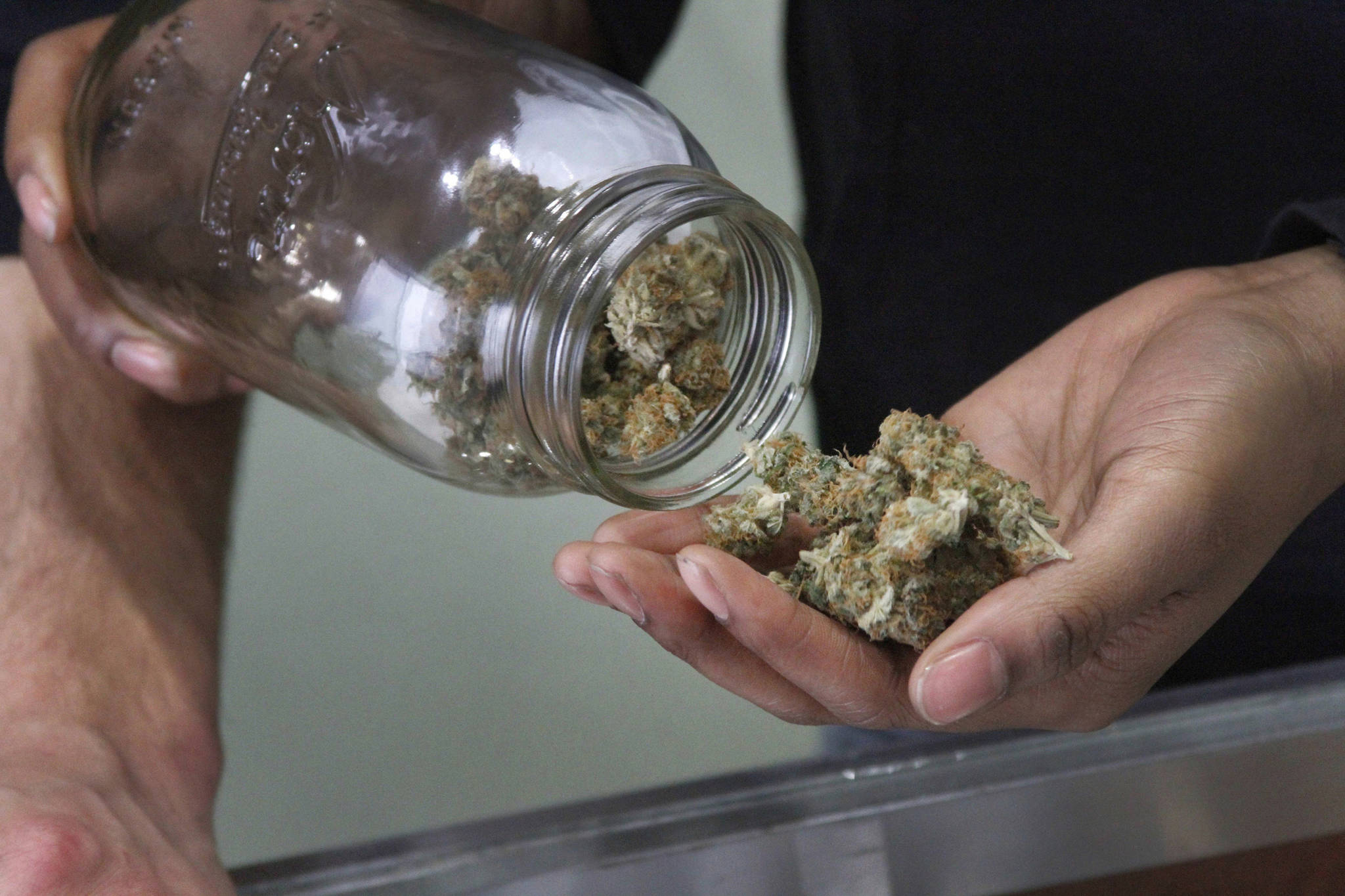 In this Feb. 20, 2015 photo, Alaska Cannabis Club CEO Charlo Greene prepares to roll a joint at the medical marijuana dispensary in Anchorage, Alaska. A law enforcement officer newly appointed to the board that regulates Alaska’s legal marijuana industry said the issue of onsite consumption should be revisited, if possible. Lt. Christopher Jaime, an Alaska Wildlife Trooper from Soldotna who also has worked as an Alaska State Trooper, acknowledges that Alaskans voted to legalize the recreational use of cannabis. He told The Associated Press that respecting the wishes of the people is important but sensible regulations also are needed. (Mark Thiessen | Associated Press File)