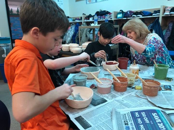 President of the Kenai Potters Guild and former Soldotna Elementary School librarian, Debbie Adamson, helps fifth-graders at Soldotna Elementary make ceramic bowls for a fundraiser that will buy buy new playground equipment for the school on Thursday, in Soldotna. (Photo by Victoria Petersen/Peninsula Clarion)