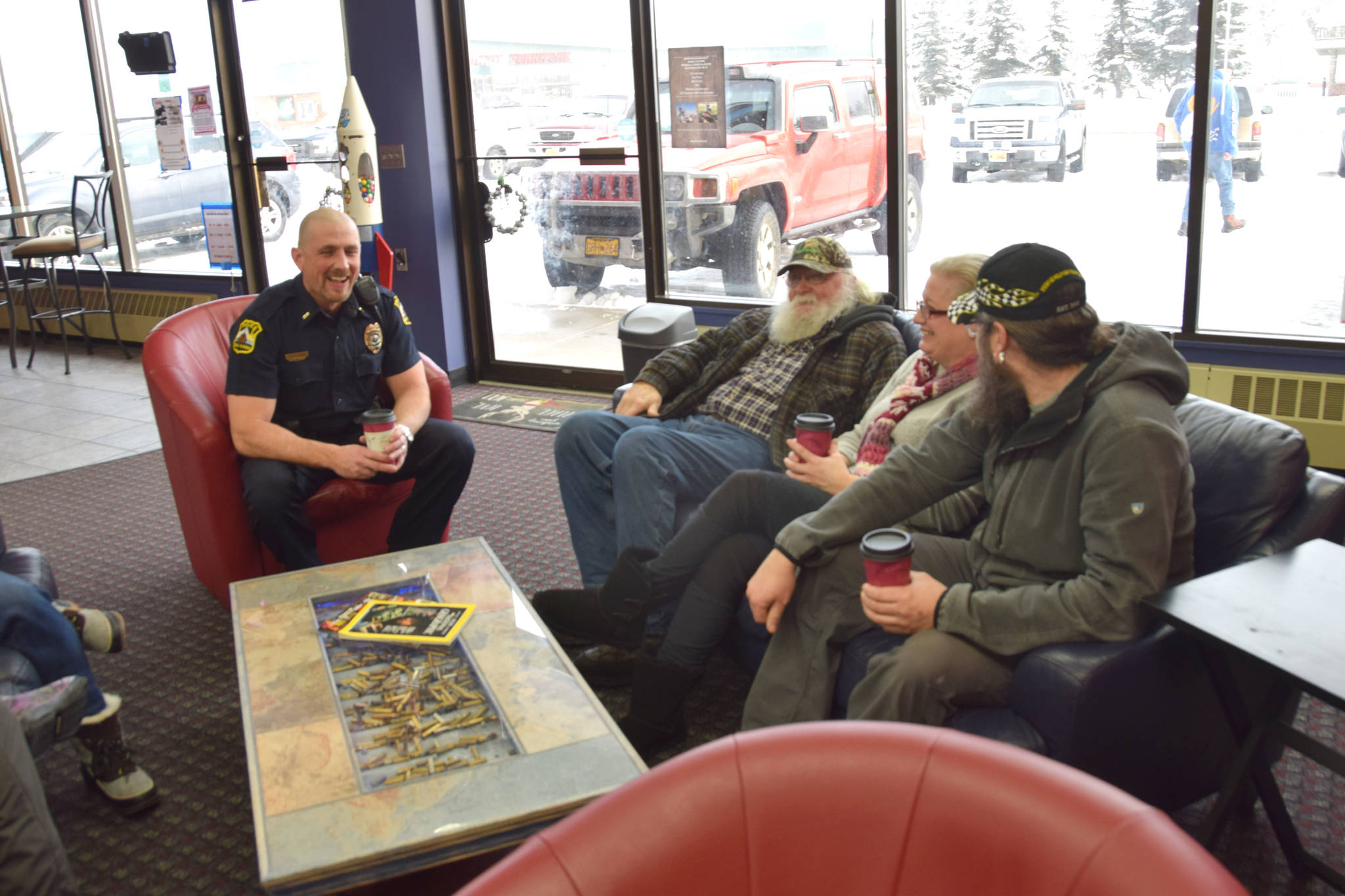 Lt. Ben Langham of the Kenai Police Department shares a laugh with members of the community at Ammo Can Coffee in Soldotna on Wednesday. (Photo by Brian Mazurek/Peninsula Clarion)