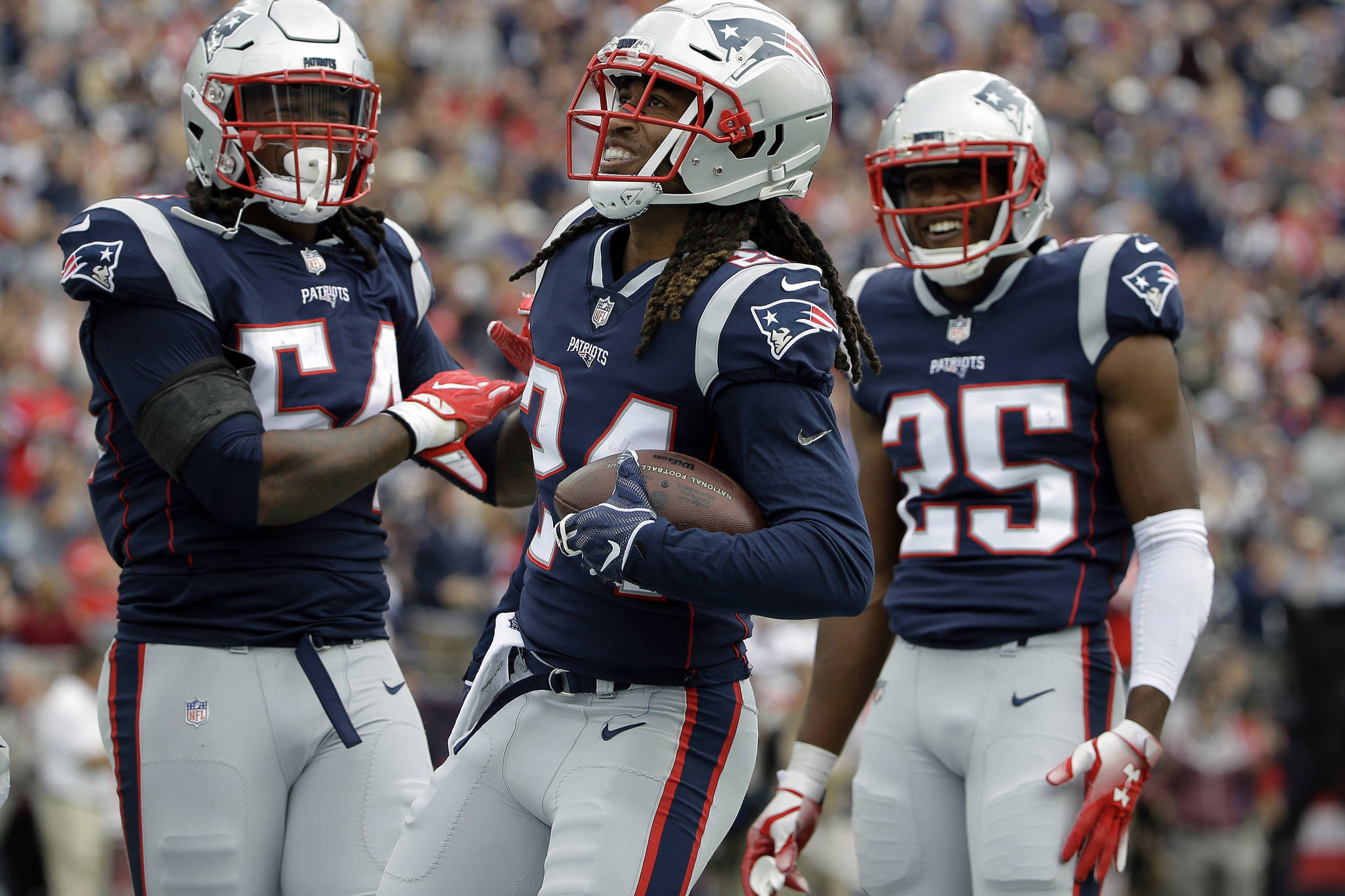 FILE - In this Sept. 9, 2018, file photo, New England Patriots defensive back Stephon Gilmore, center, celebrates his interception with Dont’a Hightower, left, and Eric Rowe, right, during the first half of an NFL football game against the Houston Texans in Foxborough, Mass. (AP Photo/Steven Senne, File)
