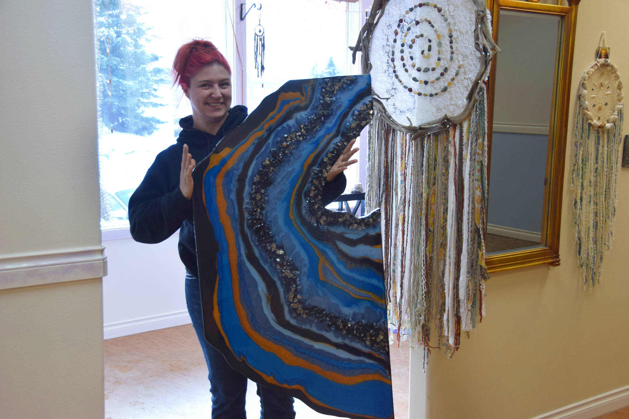 Local artist Audrey Cucullu shows off her latest piece at the Positive Vibe gallery in Kenai on Wednesday, Jan. 30, 2019. (Photo by Brian Mazurek/Peninsula Clarion)