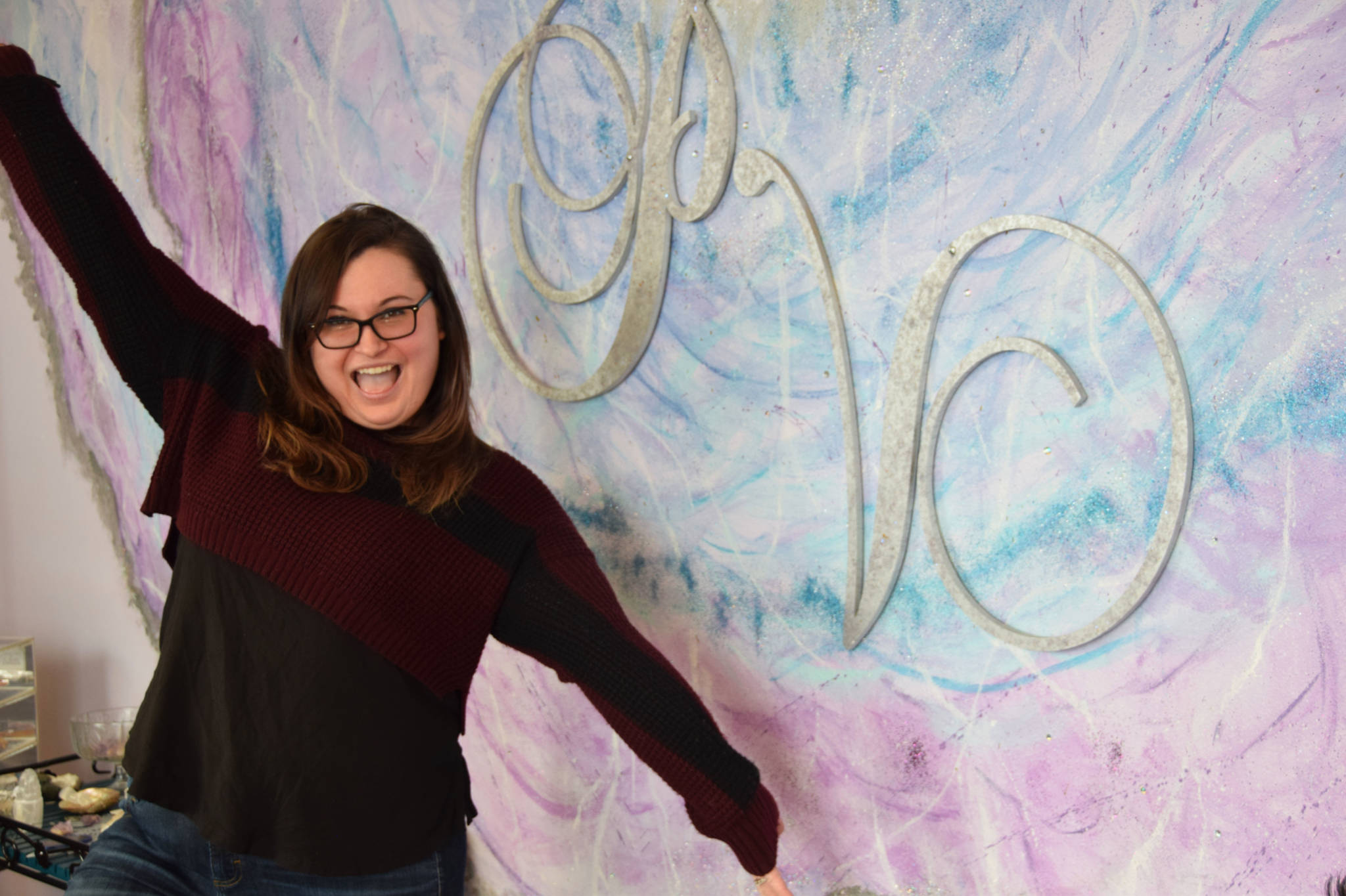 Local business owner Kylee Swircenski poses in front of the logo of her store, Positive Vibe, on Wednesday, Jan. 30, 2019 in Kenai. (Photo by Brian Mazurek/Peninsula Clarion)