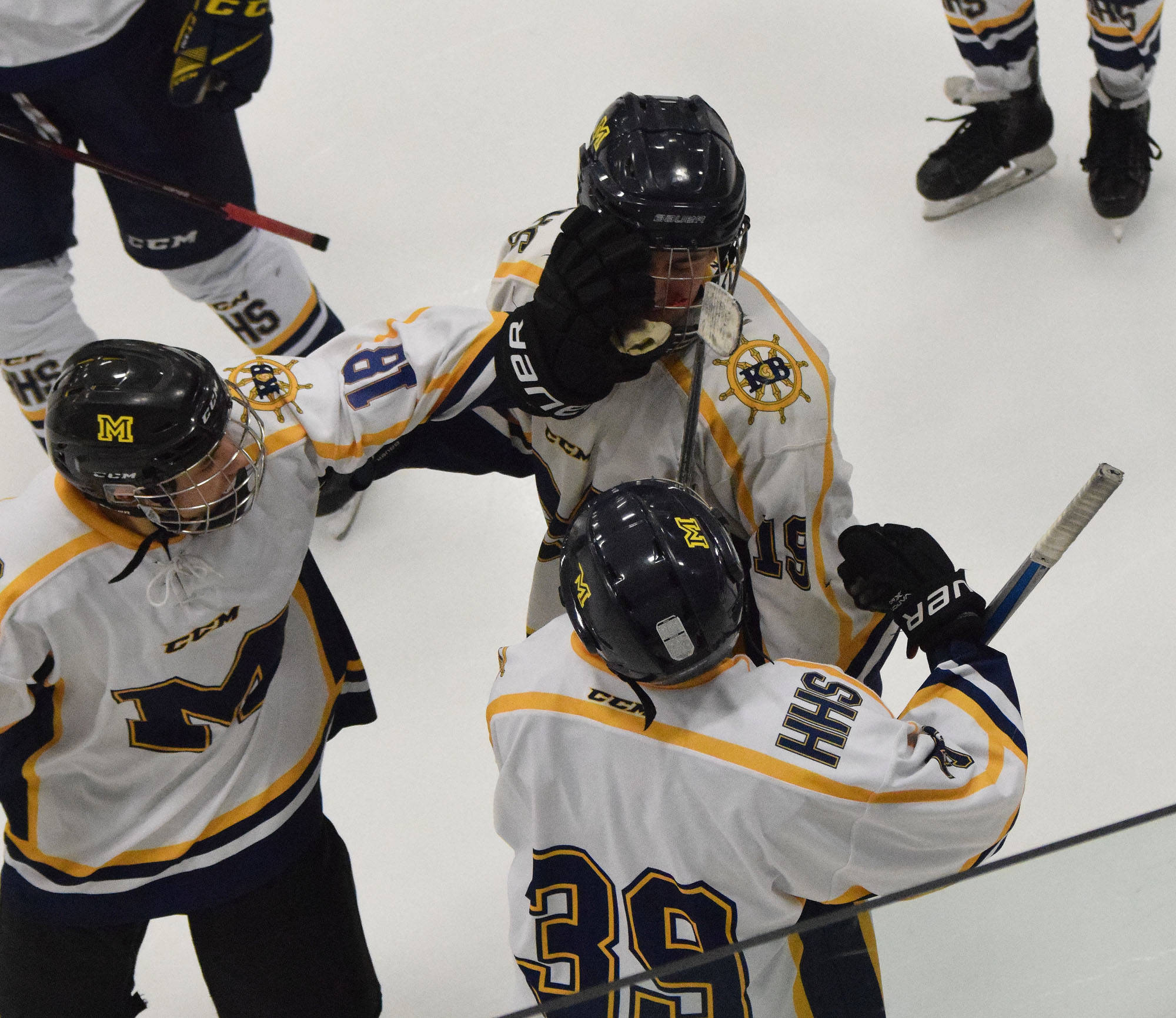 Homer’s Aiden Ross (middle) receives congratulations from teammates Thursday after scoring against Glennallen at the Div. II state hockey championship tournament in Wasilla. (Photo by Joey Klecka/Peninsula Clarion)