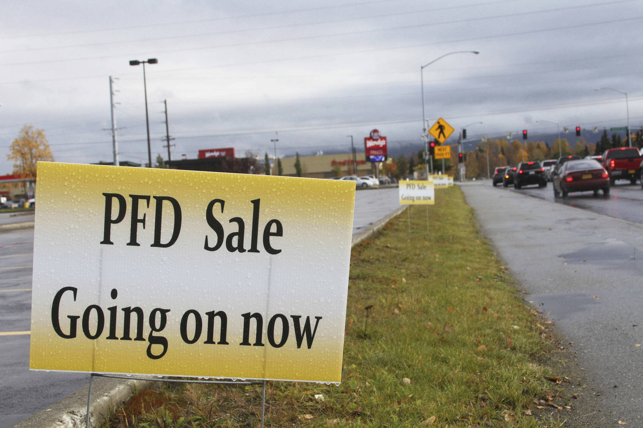 In this Oct. 4, 2017 file photo, a sign meant to entice recipients of payouts from the state’s Permanent Fund Dividend Division, also known as PFD, advertises a sale in Anchorage, Alaska. The Alaska Department of Revenue has shut down online applications for Alaska Permanent Fund dividends because of security concerns. The department in an announcement Tuesday, Jan. 1, 2019, said some applicants had inadvertently seen personal information belonging to other applicants who had filed previously. (AP Photo/Mark Thiessen, File)