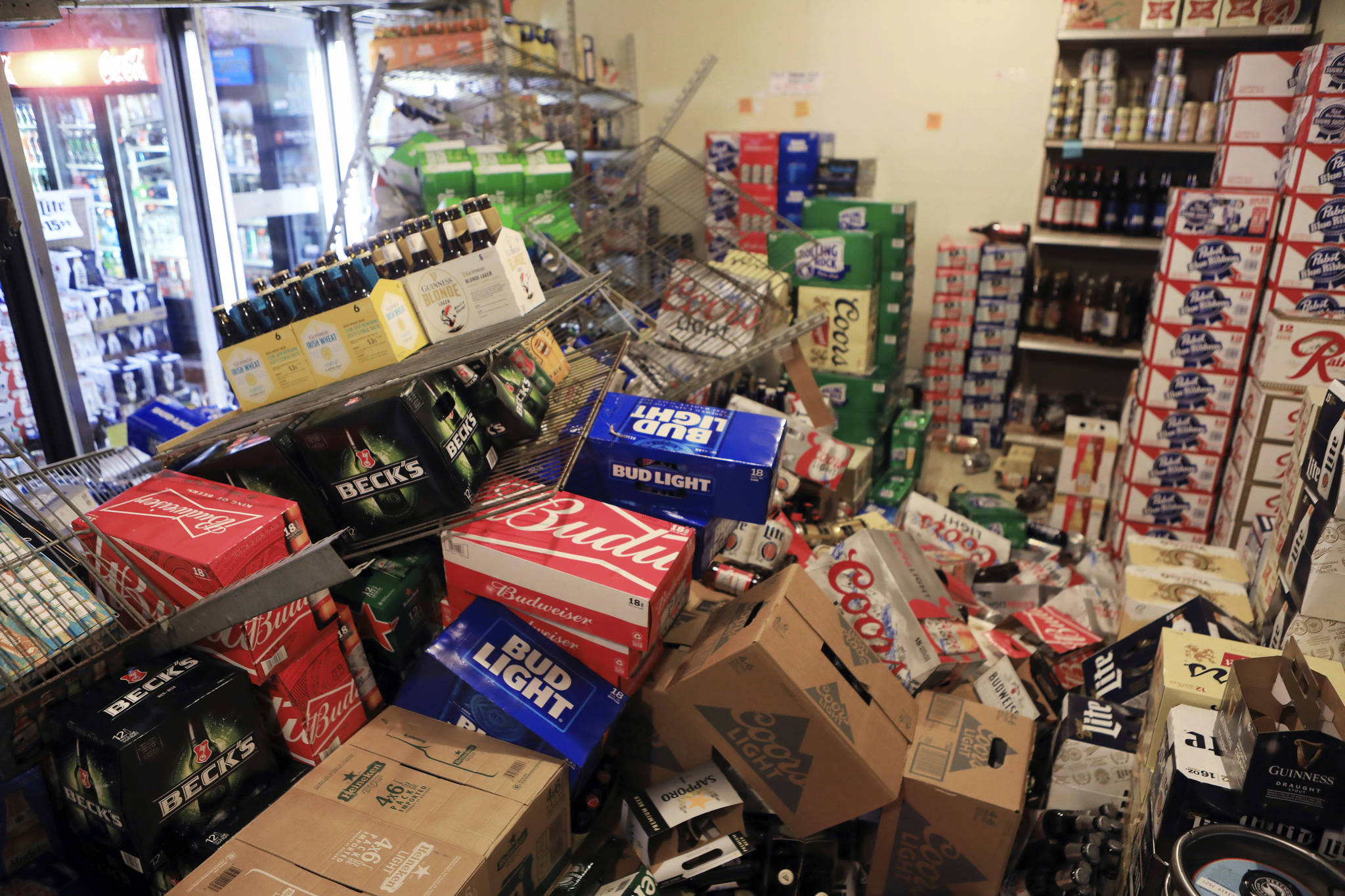 This Nov. 30, 2018 file photo shows cases of beer jumbled in a walk-in cooler at Value Liquor after an earthquake in Anchorage. (AP Photo/Dan Joling, File)