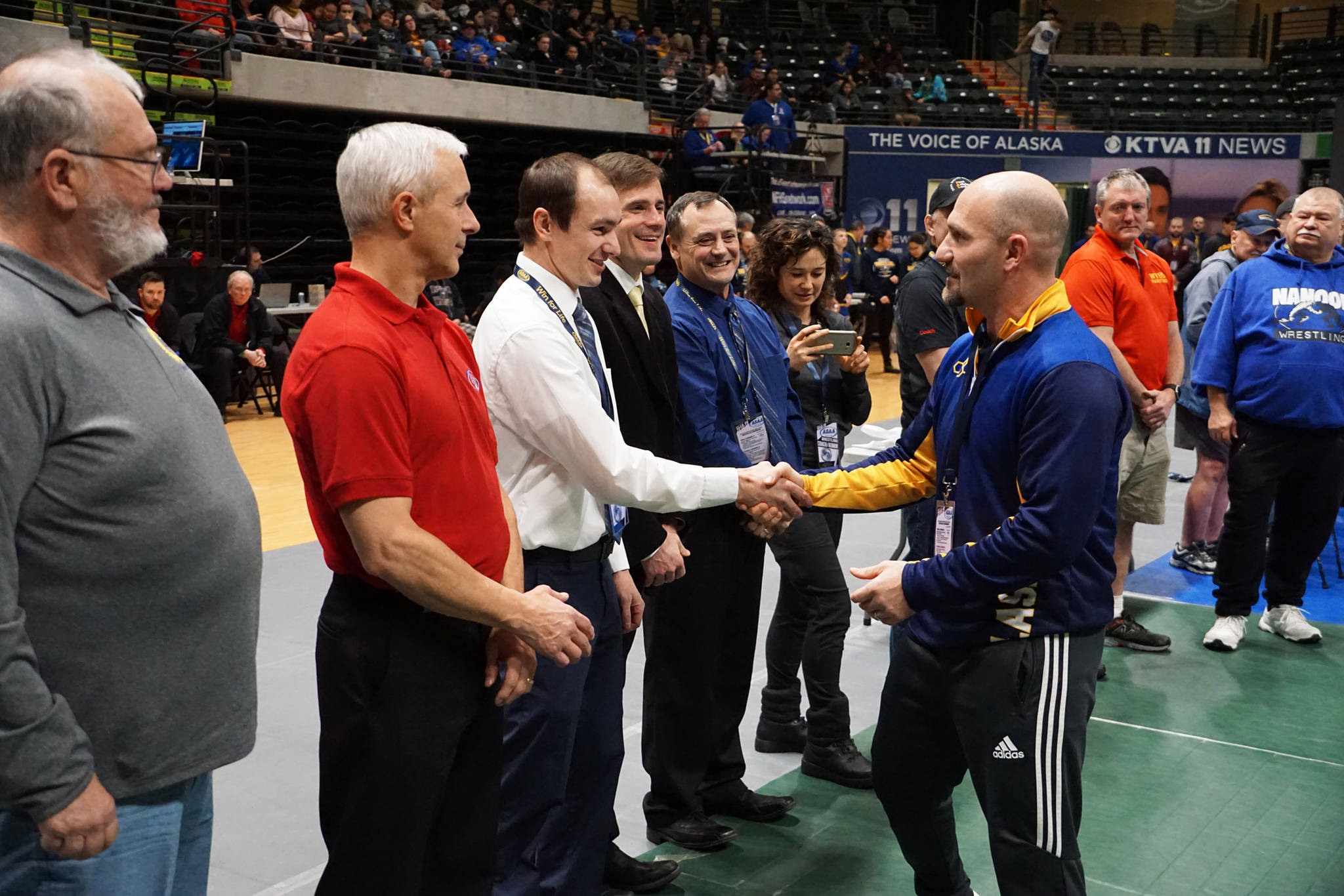 Homer High School Athletic Director Chis Perk, right in blue, is inducted into the Alaska Wrestling Hall of Fame on Dec. 15, 2018 at the Alaska Airlines Center in Anchorage, Alaska. (Photo courtesy Alaska Schools Activity Association)
