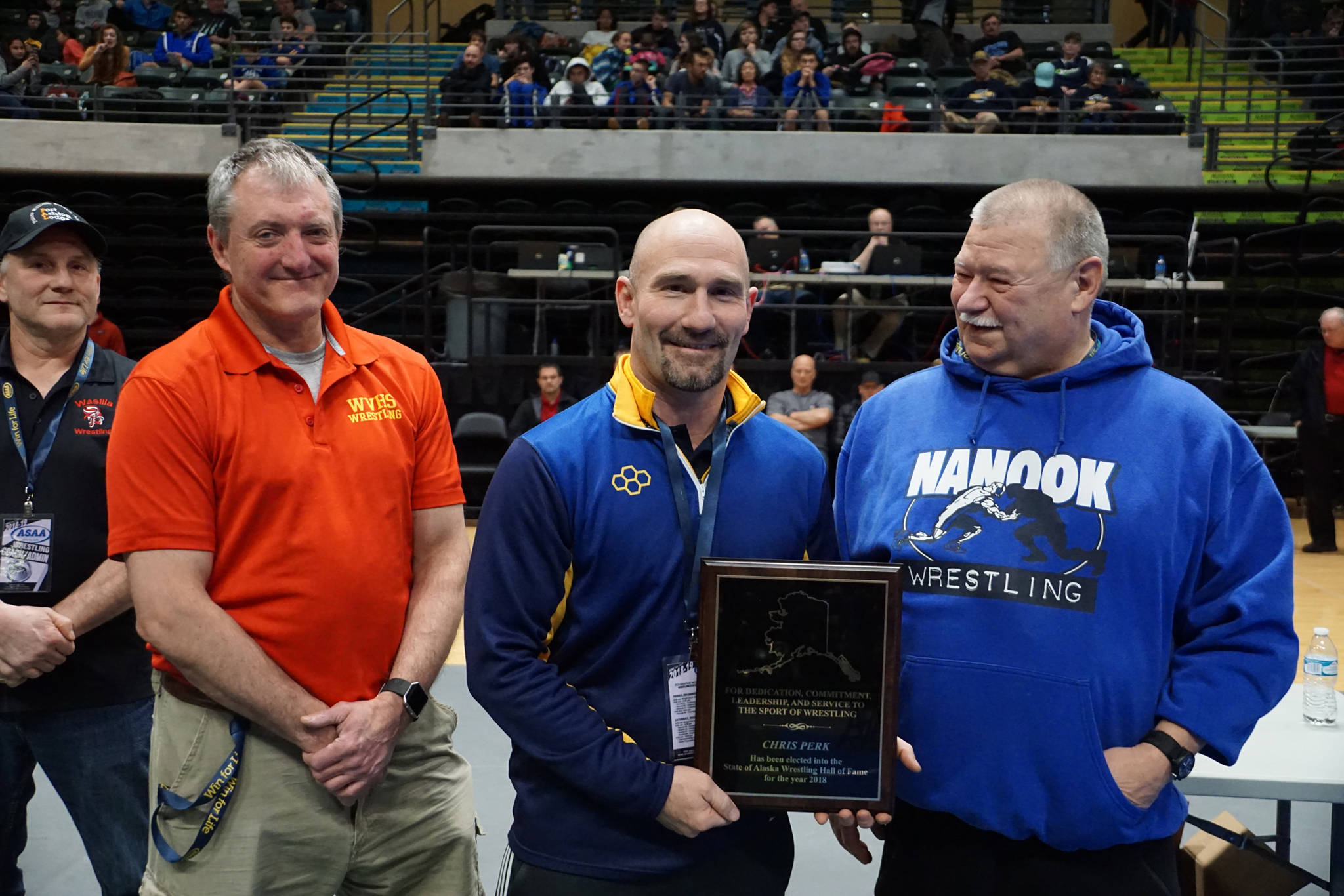 Homer High School Athletic Director Chis Perk, center, is inducted into the Alaska Wrestling Hall of Fame on Dec. 15, 2018 at the Alaska Airlines Center in Anchorage, Alaska. (Photo courtesy Alaska Schools Activity Association)