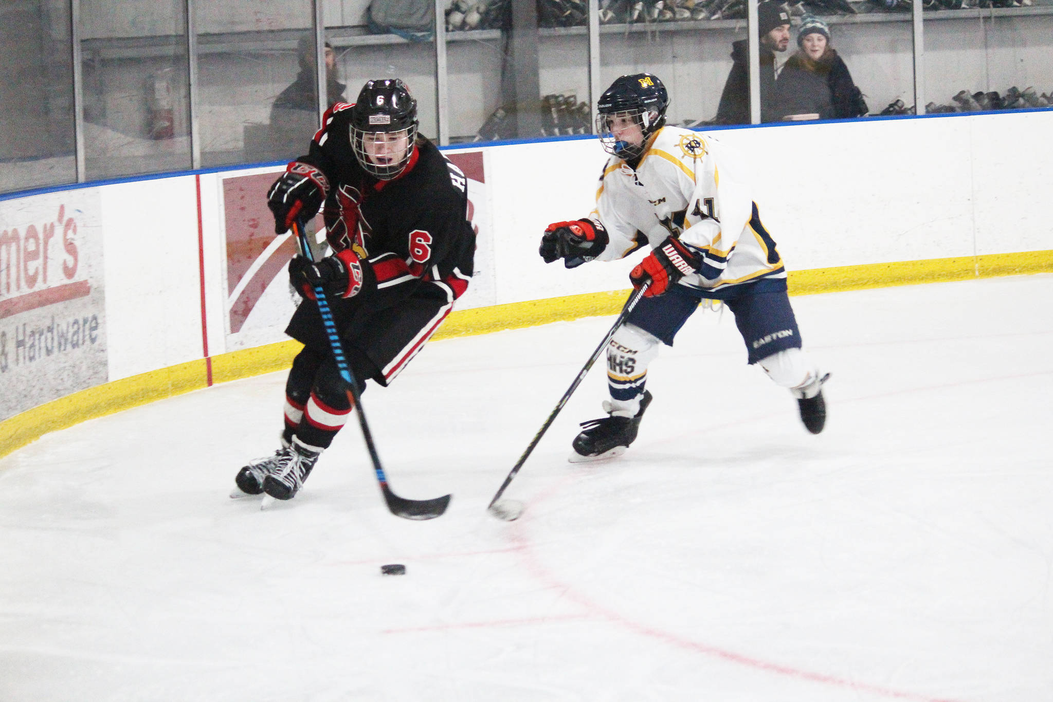 Homer’s Kazden Stineff keeps pressure on Kenai’s Wyatt Harvey during a game between the two schools Tuesday, Jan. 8, 2019 at Kevin Bell Ice Arena in Homer, Alaska. (Photo by Megan Pacer/Homer News)