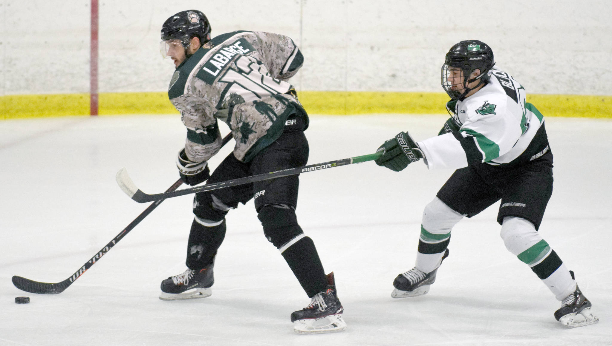 Kenai River Brown Bears forward Trey LaBarge protects the puck from Chippewa (Wisconsin) Steel defenseman Michael Black on Friday, Jan. 11, 2019, at the Soldotna Regional Sports Complex. (Photo by Jeff Helminiak/Peninsula Clarion)