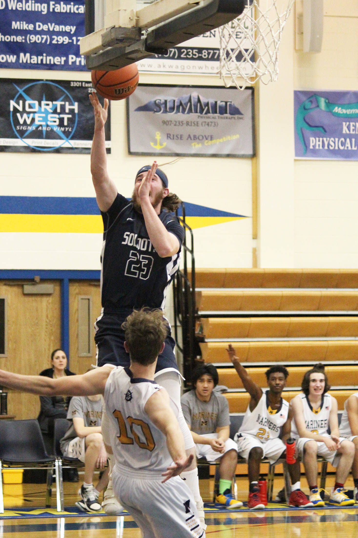 Soldotna High School’s David Michael bolls over Homer’s Seth Adkins while taking a shot during a Tuesday, Jan. 15, 2019 game in Homer, Alaska. (Photo by Megan Pacer/Homer News)