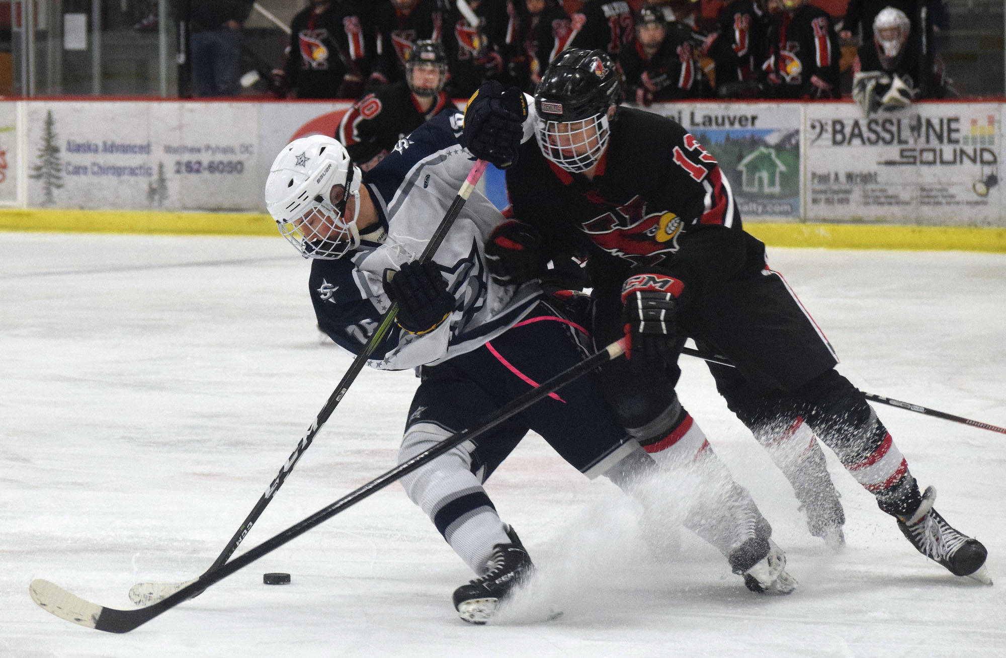 Kenai’s Aidan Milburn (right) and Soldotna’s Dylan Walton fight for the puck Wednesday night in a conference game at the Soldotna Regional Sports Complex. (Photo by Joey Klecka/Peninsula Clarion)