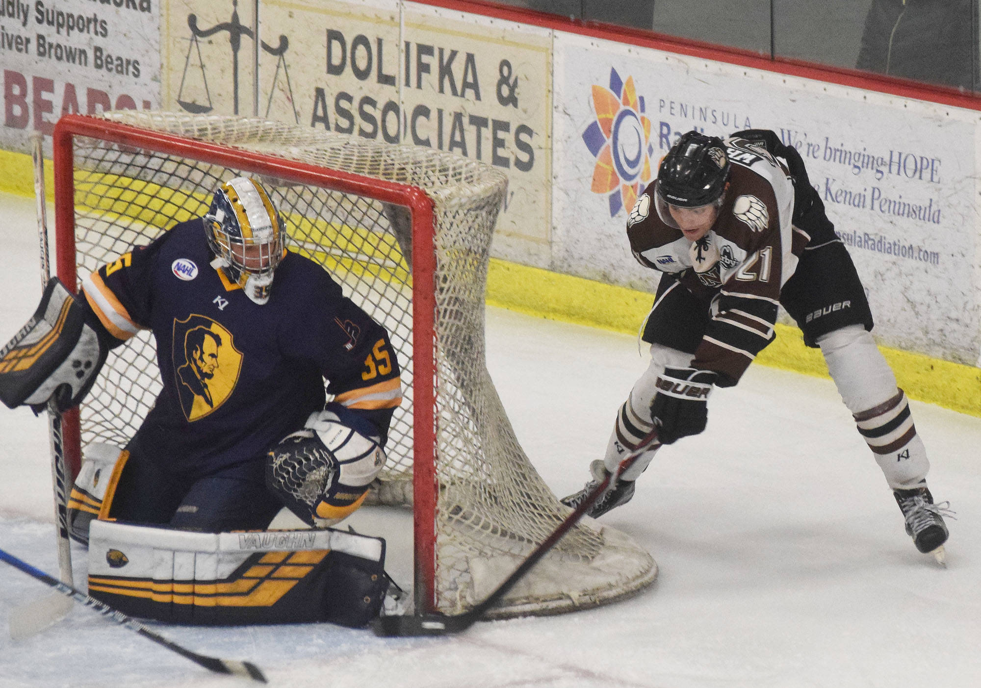 Kenai River’s Brendan White (right) tries a wraparound shot on Springfield goalie Jack Williams, Thursday night in a North American Hockey League contest against the Springfield (Illinois) Jr. Blues at the Soldotna Regional Sports Complex. (Photo by Joey Klecka/Peninsula Clarion)