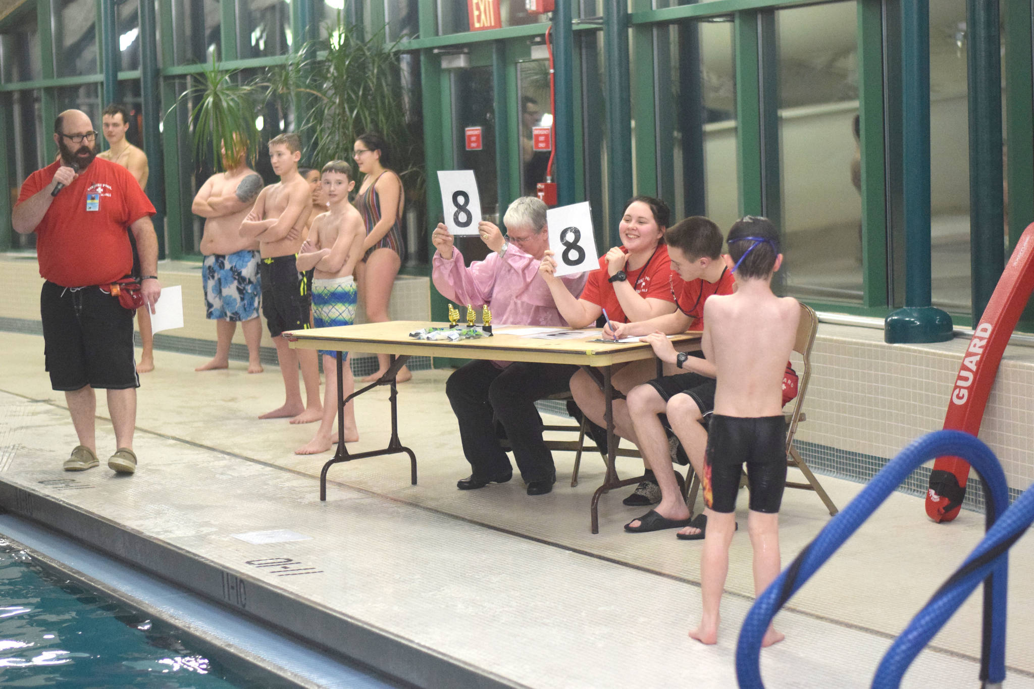 Judges Jenny Long and Treasa Cooper score one of the jumps during the cannonball contest at the Nikiski Pool on Thursday, Jan. 17, 2019. (Photo by Brian Mazurek/Peninsula Clarion)