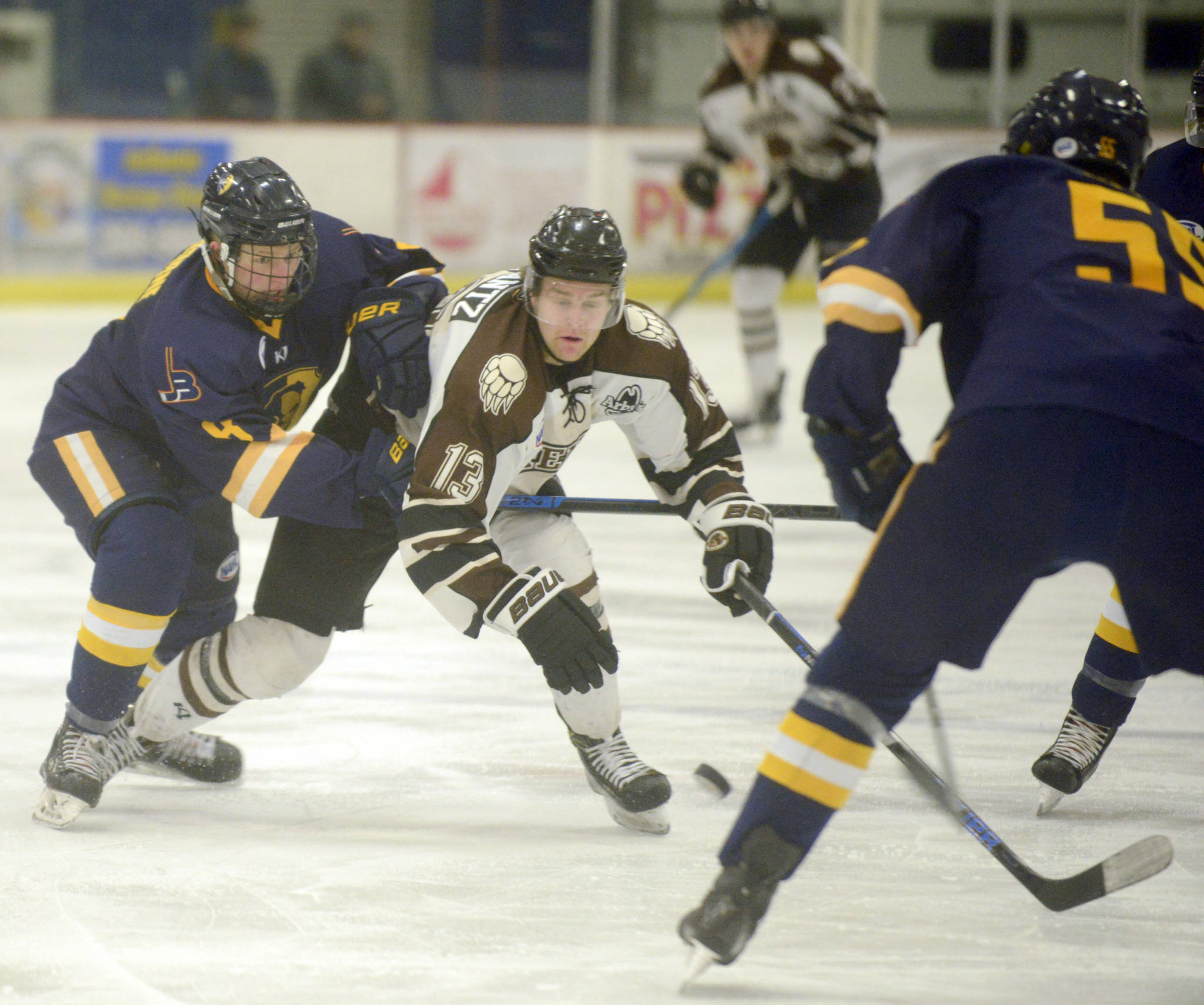 Kenai River Brown Bears forward Sebastian Frantz tries to work the puck between Max Osborne and Jayden Jensen of the Springfield (Illinois) Jr. Blues on Friday, Nov. 18, 2019, at the Soldotna Regional Sports Complex. (Photo by Jeff Helminiak/Peninsula Clarion)