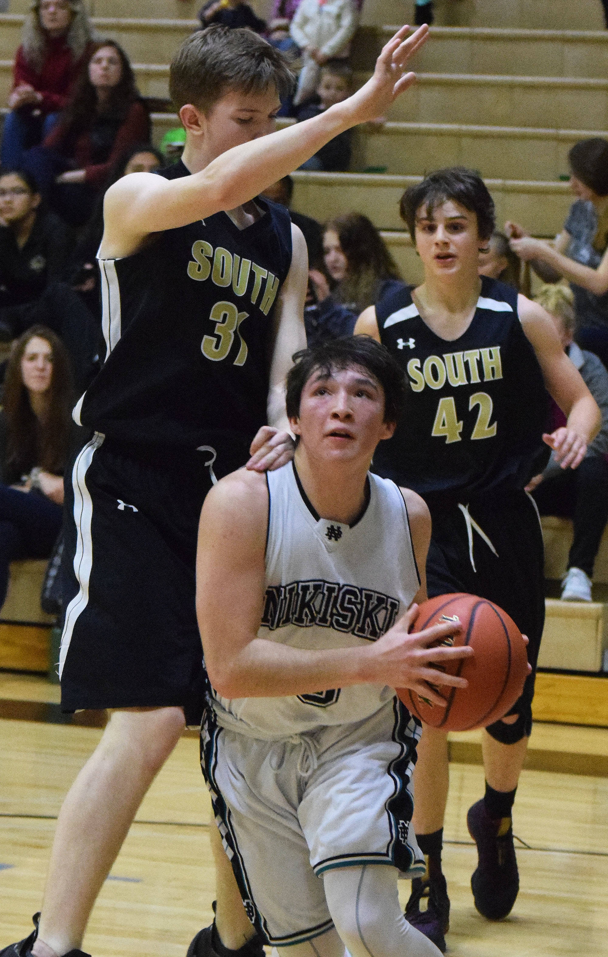 Nikiski’s Michael Mysing makes a move to the rim by South’s Shane Wardhaugh (left) Saturday at the Rus Hitchcock Nikiski Tip Off tournament. (Photo by Joey Klecka/Peninsula Clarion)