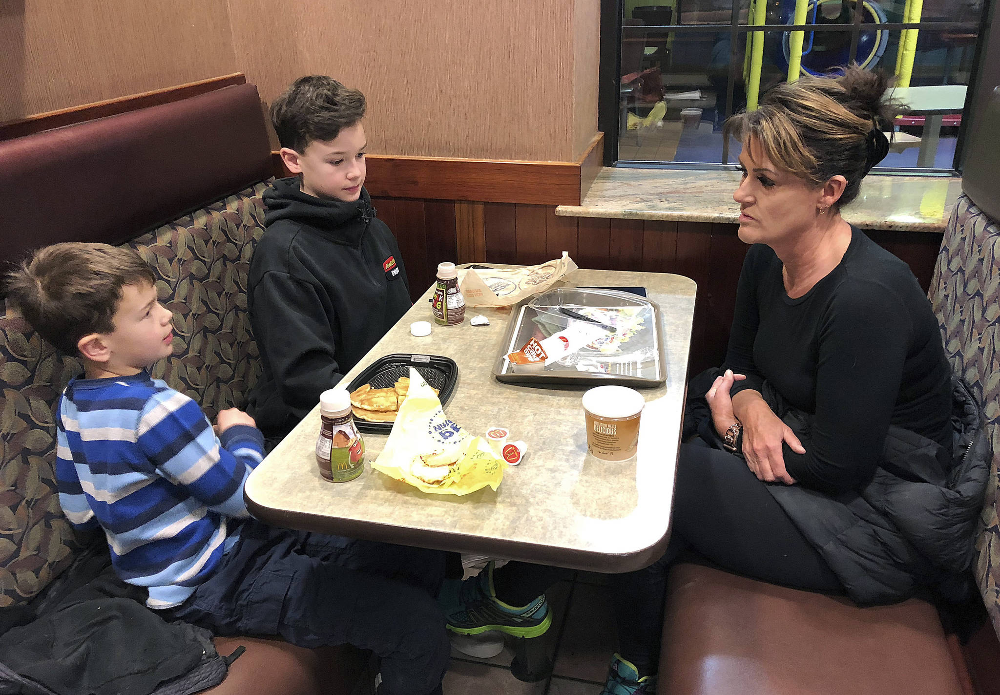 In this Jan. 10, 2019, photo, Tamra Cartwright, right, talks with sons Connor, 7, left, and Caden, 11, about the effect of multiple aftershocks from Alaska’s recent magnitude 7.0 earthquake while interviewed in Anchorage, Alaska. Connor Cartwright says the aftershocks terrify him, and he fears his Anchorage home won’t hold up. (AP Photo/Rachel D’Oro)
