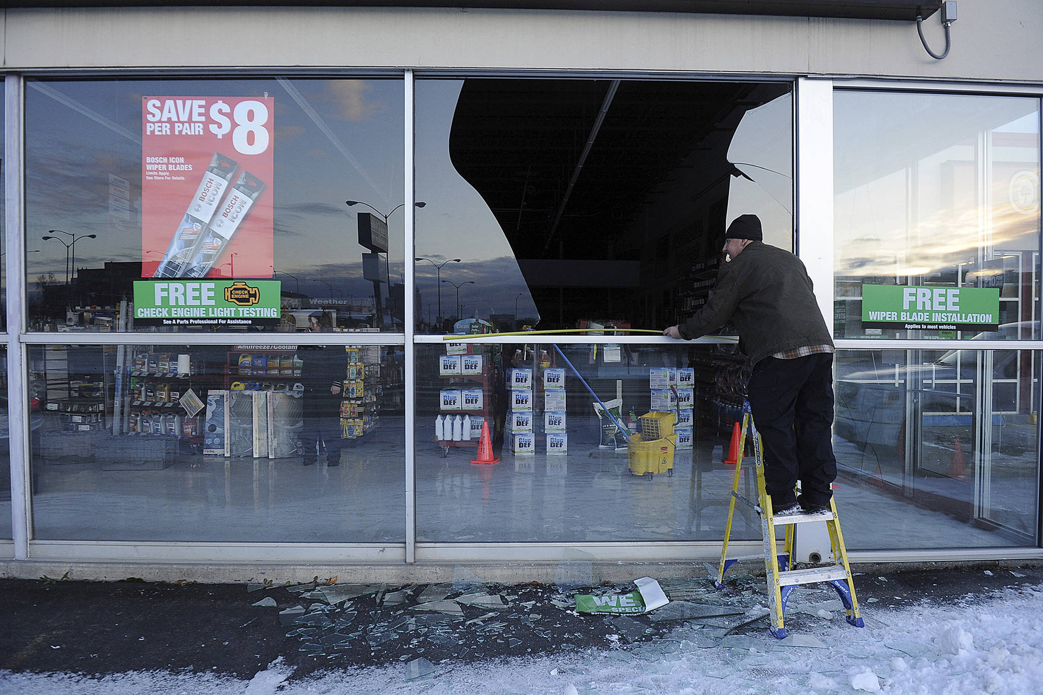 In this Nov. 30, 2018, file photo, Dennis Keeling, of Instant Services, measures for a broken window at an auto parts store following an earthquake in Anchorage, Alaska Seven weeks after the massive earthquake struck Alaska, the seemingly endless aftershocks are keeping many residents filled with anxiety. (AP Photo/Mike Dinneen, file)