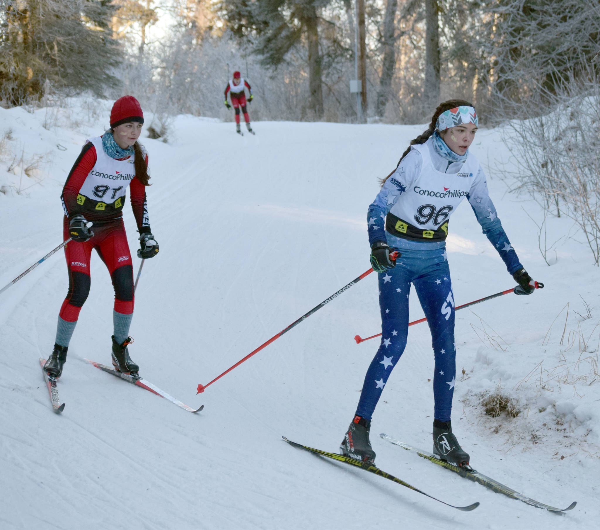 Kenai Central’s Summer Foster and Soldotna’s Erika Arthur round a corner during Besh Cup 3 at Tsalteshi Trails on Sunday, Jan. 20, 2019. (Photo by Jeff Helminiak/Peninsula Clarion)