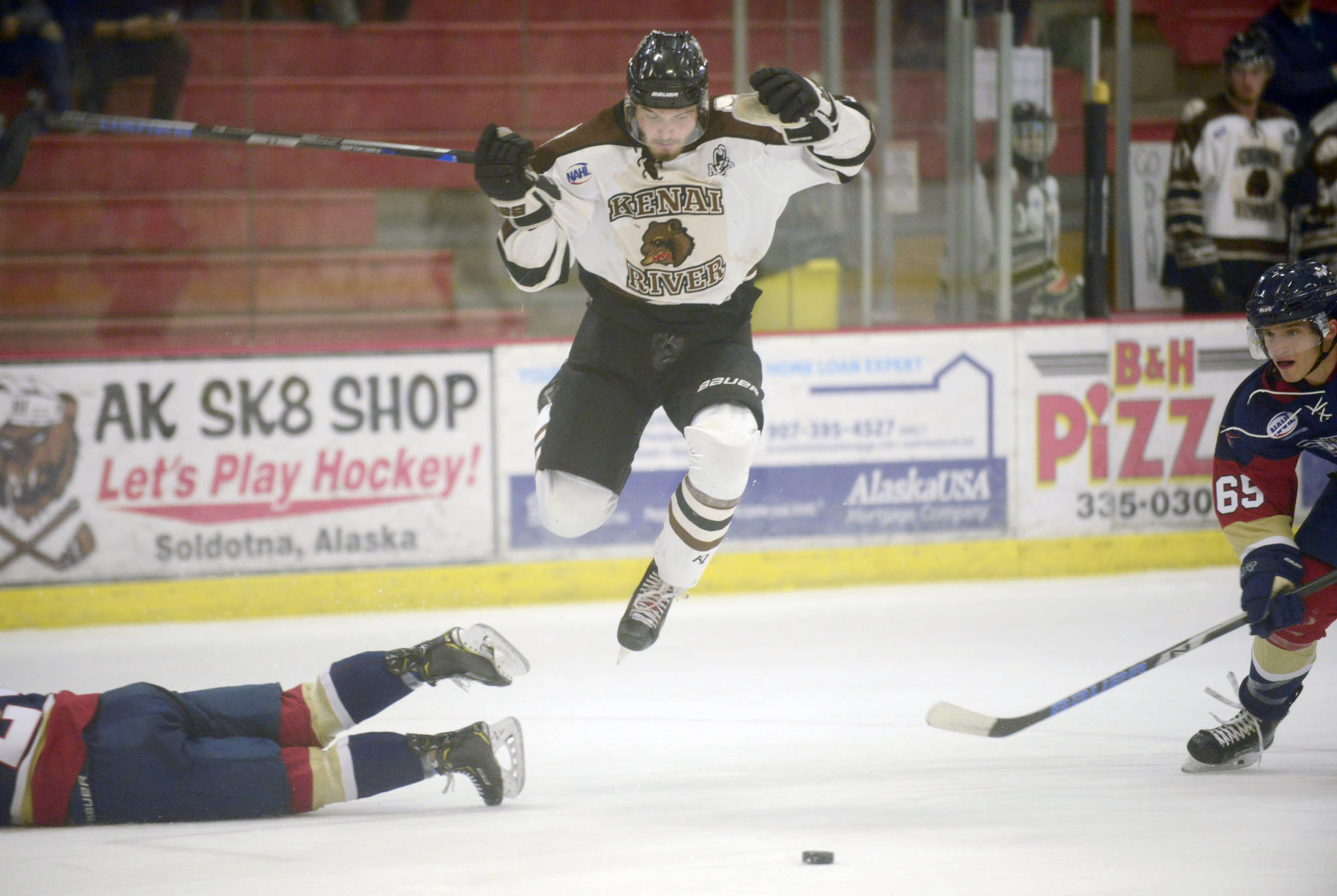 Kenai River Brown Bears forward Trey LaBarge jumps between Cole Thiessen and Shane Hathaway of the Topeka (Kansas) Pilots on Friday, Feb. 2, 2019, at the Soldotna Regional Sports Complex. (Photo by Jeff Helminiak/Peninsula Clarion)