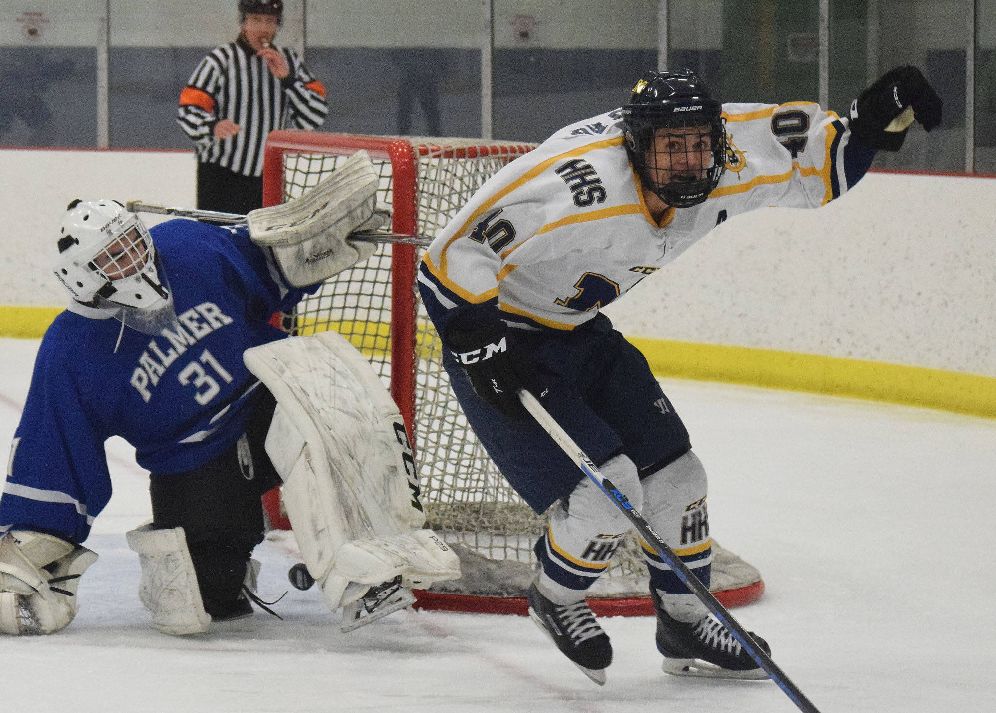Homer’s Isaiah Nevak celebrates a late game-tying goal on Palmer goalie Tiernan O’Rourke Saturday night at the Curtis Menard Sports Complex in Wasilla. (Photo by Joey Klecka/Peninsula Clarion)