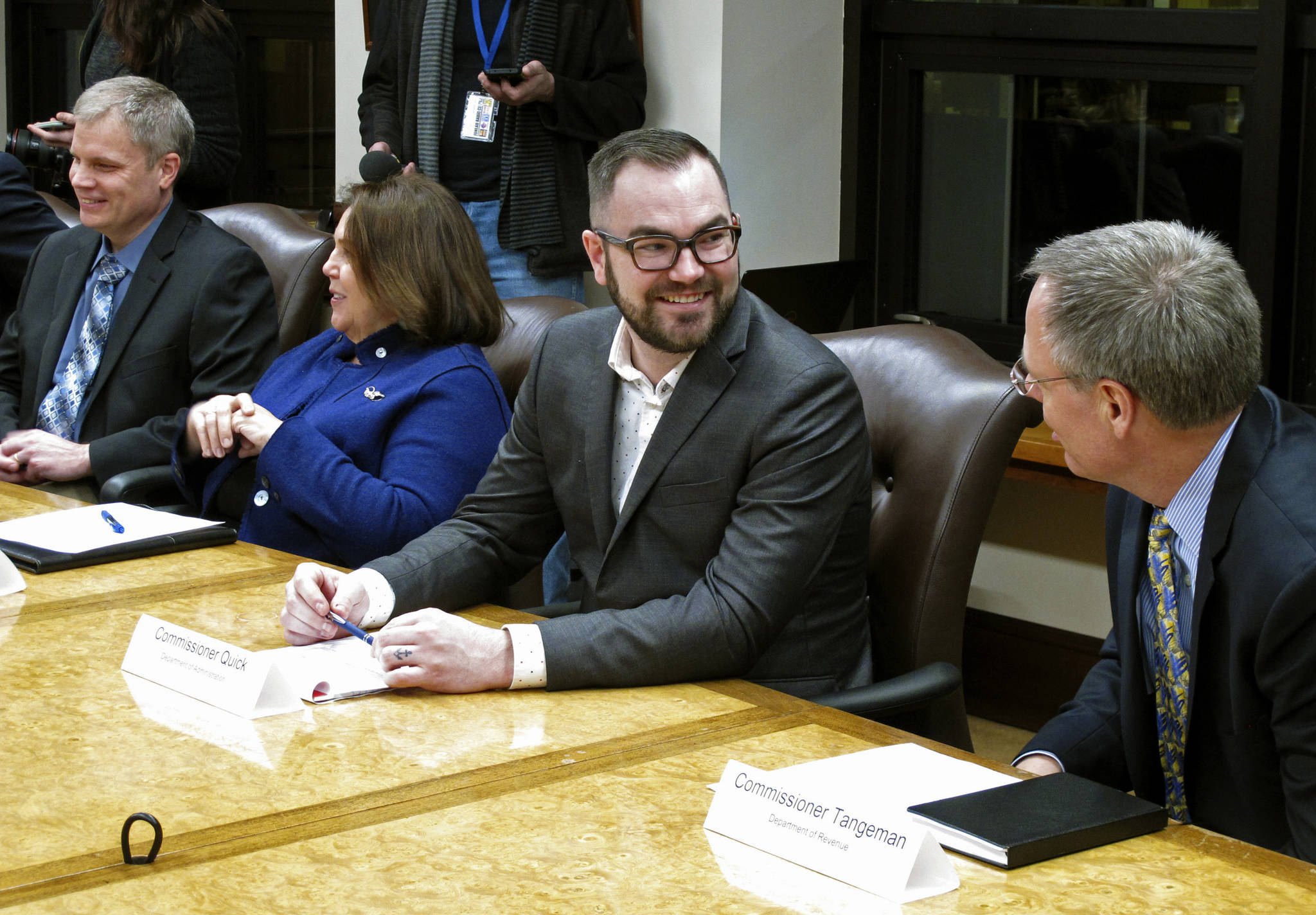 In this Jan. 8 file photo, Alaska Department of Administration Commissioner Jonathan Quick, second from right, speaks with Revenue Commissioner Bruce Tangeman, right, before the start of a cabinet meeting at the state Capitol in Juneau, Alaska. (AP Photo/Becky Bohrer, File)