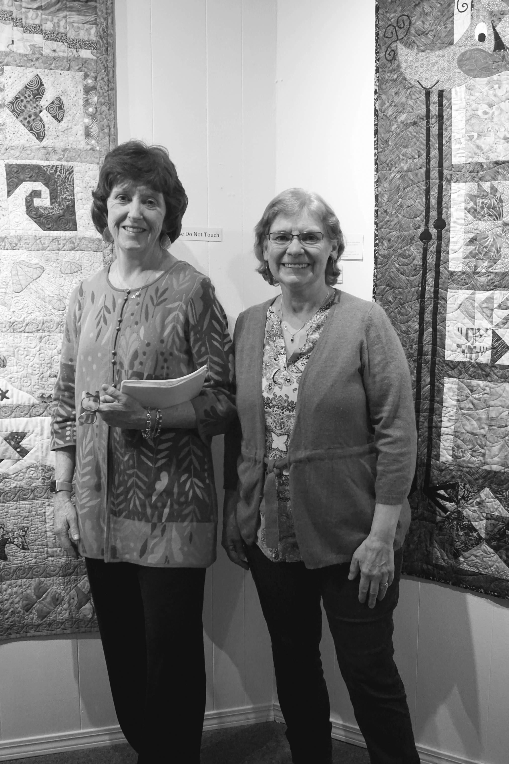 Patrice Krant, left, and Janet Bacher, right, stand by their quilts in the “9 Women / 9 Quilts” show that opened last Friday, Feb. 1, 2019, at the Homer Council on the Arts, in Homer, Alaska. (Photo by Michael Armstrong/Homer News)