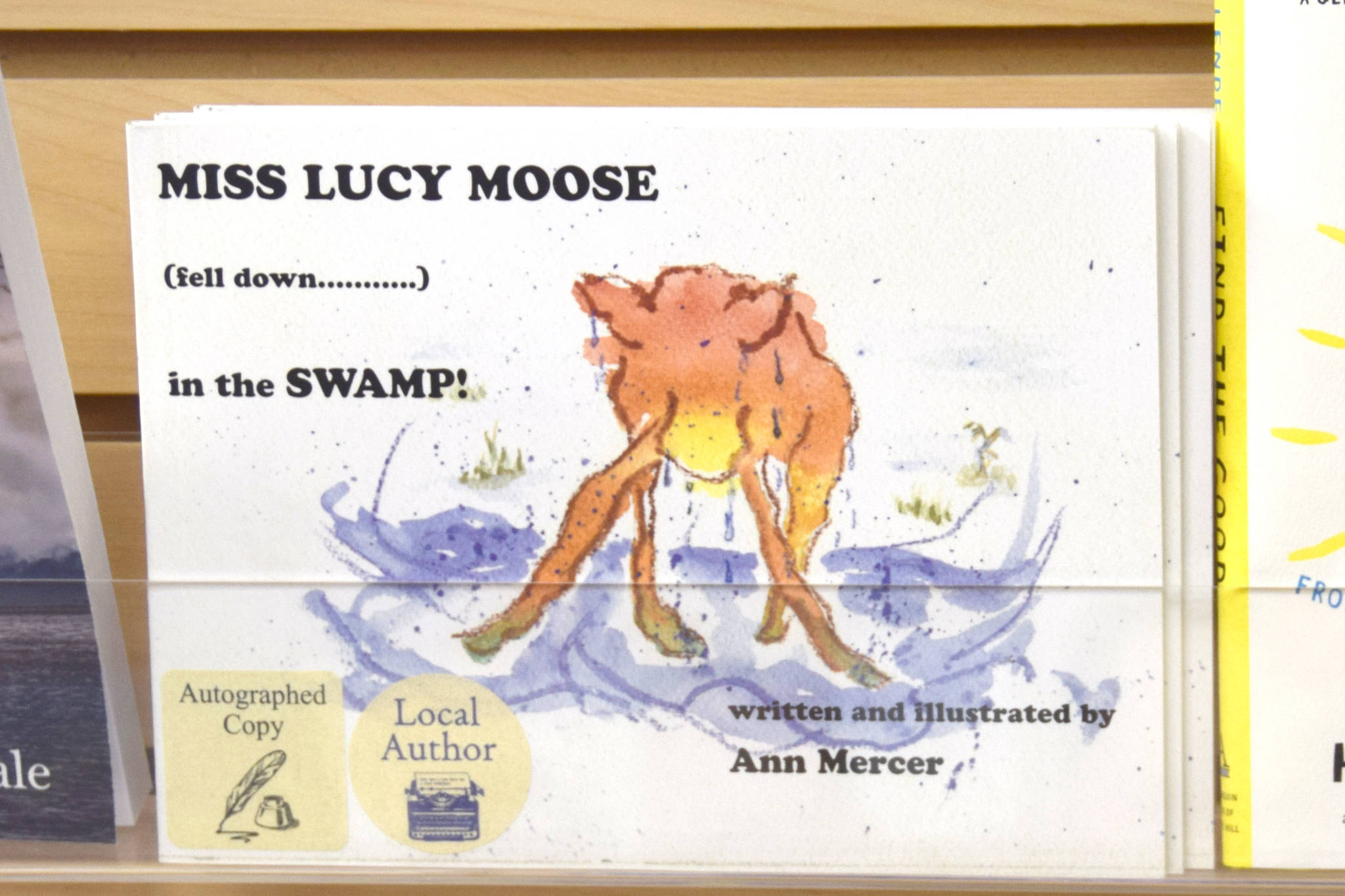 Local author Ann Mercer’s first book, “Miss Lucy Moose Falls Down in the Swamp” sits on the shelves of River City Books in Soldotna. (Photo by Brian Mazurek/Peninsula Clarion)