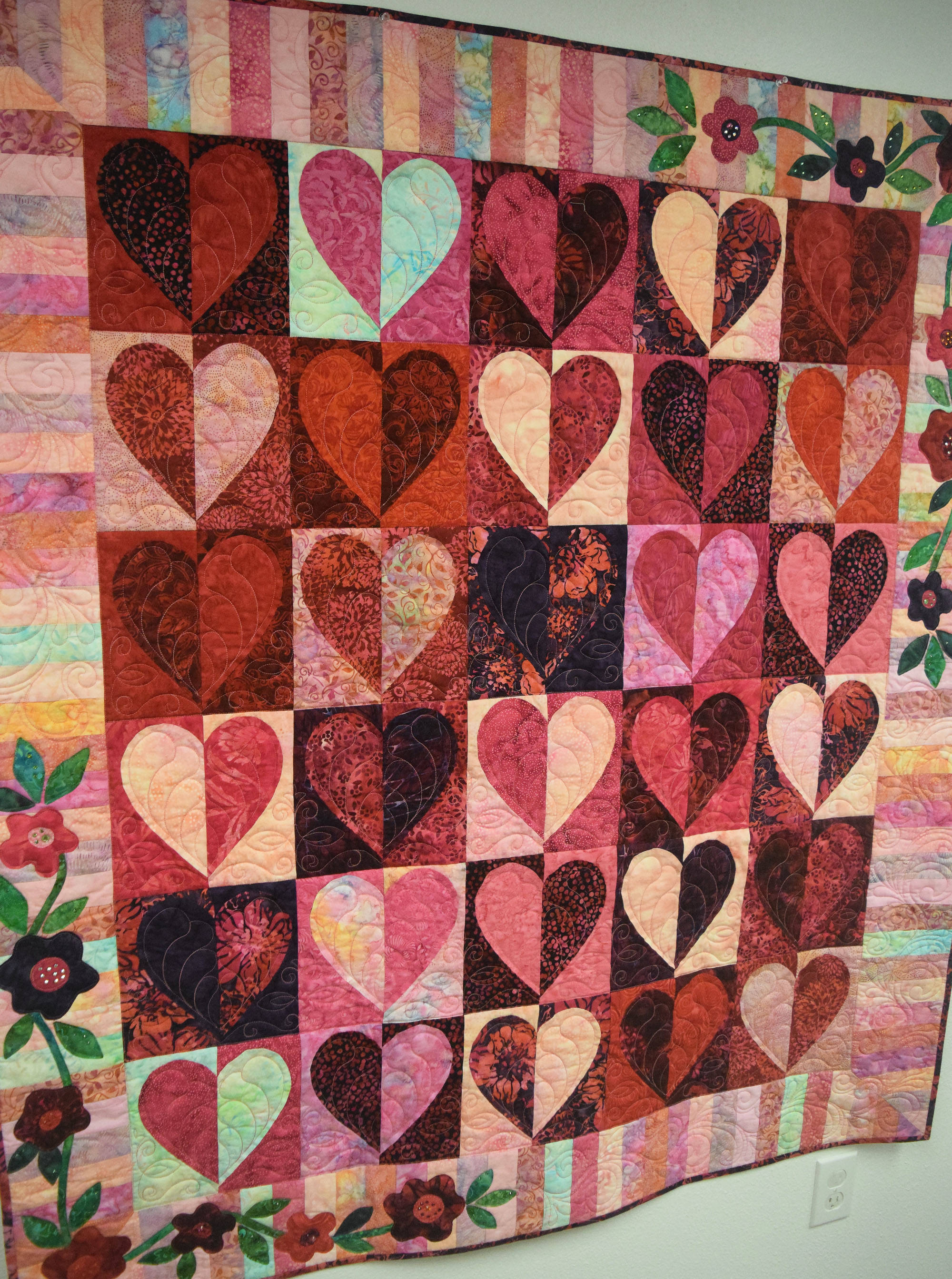 ”Heart to Heart”, a quilt produced by local artist Pat Reese, hangs on the wall Thursday at the Kenai Fine Arts Center. (Photo by Joey Klecka/Peninsula Clarion)