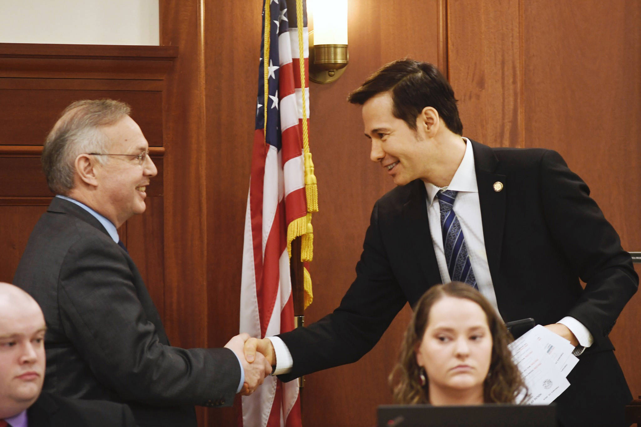 Speaker Pro Tempore Neal Foster, D-Nome, right, shakes hands with newly elected Speaker of the House Bryce Edgmon, D-Dillingham, in the House on Thursday, Feb. 14, 2019. (Michael Penn | Juneau Empire)