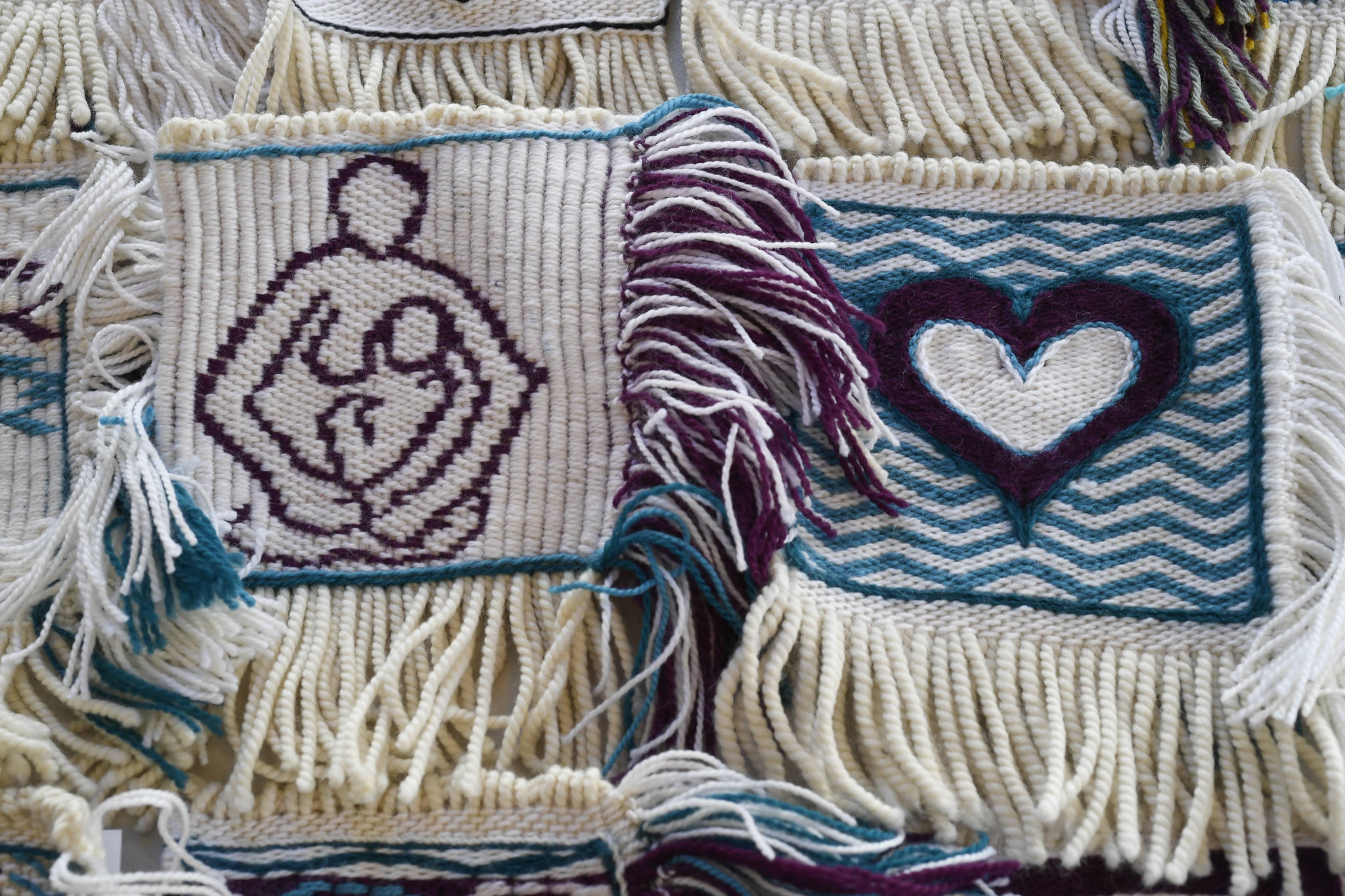 Woven squares by Chloe French, left, and Kathryn Rousso are part of the Giving Strength Robe project on Friday, Feb. 15, 2019. Juneau weaver Lily Hope is organizing dozens of Chilkat and Ravenstail weavers from all over North America to weave 5-inch-by-5-inch squares that will be combined to make one traditional indigenous robe. Once completed, the robe will be given to Aiding Women in Abuse and Rape Emergencies (AWARE). (Michael Penn | Juneau Empire)