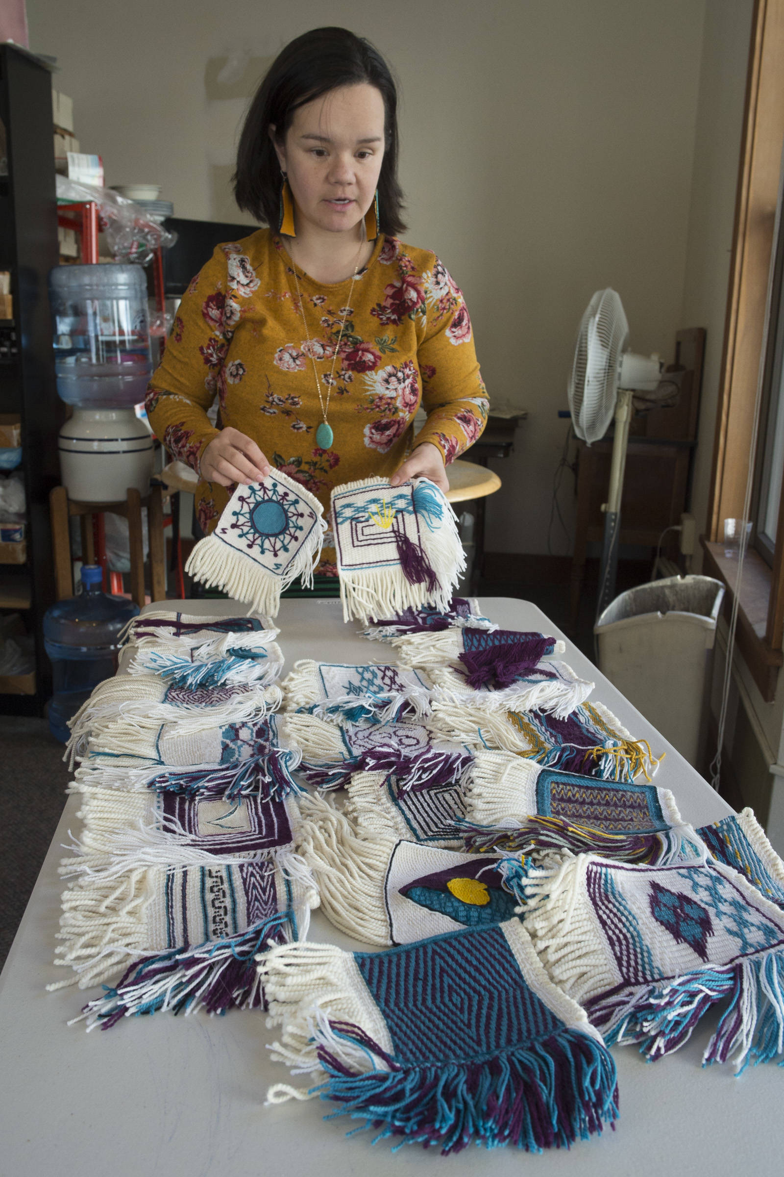 Weaver Lily Hope lays out woven squares for a new project called the Giving Strength Robe on Friday, Feb. 15, 2019. (Michael Penn | Juneau Empire)
