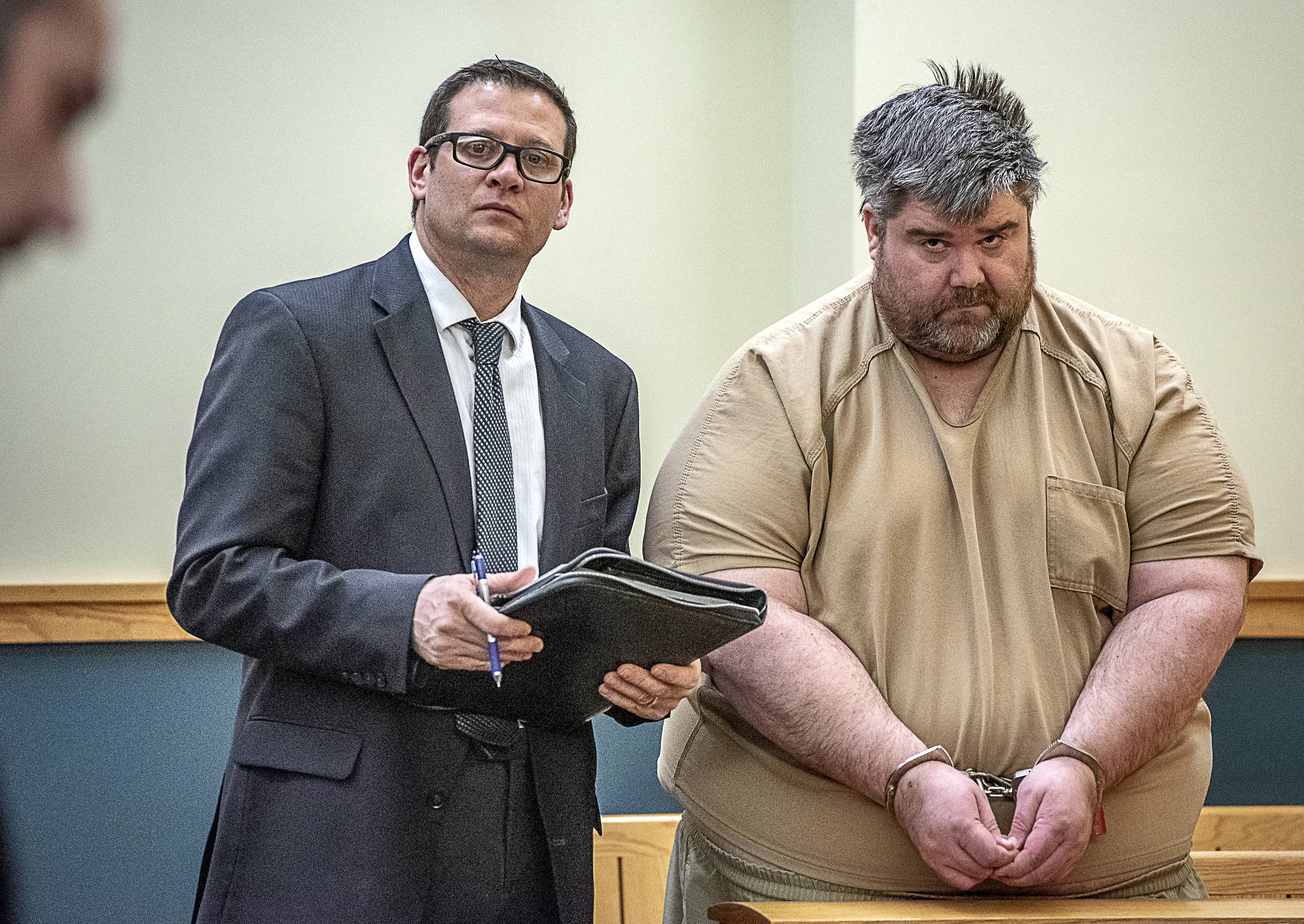 Steven Downs, 44, of Auburn, Maine, right, stands for his initial appearance in 8th District Court in Lewiston, Maine, on Tuesday. Downs has been charged with the 1993 rape and murder of 20-year-old Sophie Sergie at the University of Alaska Fairbanks. Standing with Downs is Attorney Richard Charest. (Andree Kehn/Sun Journal via AP)