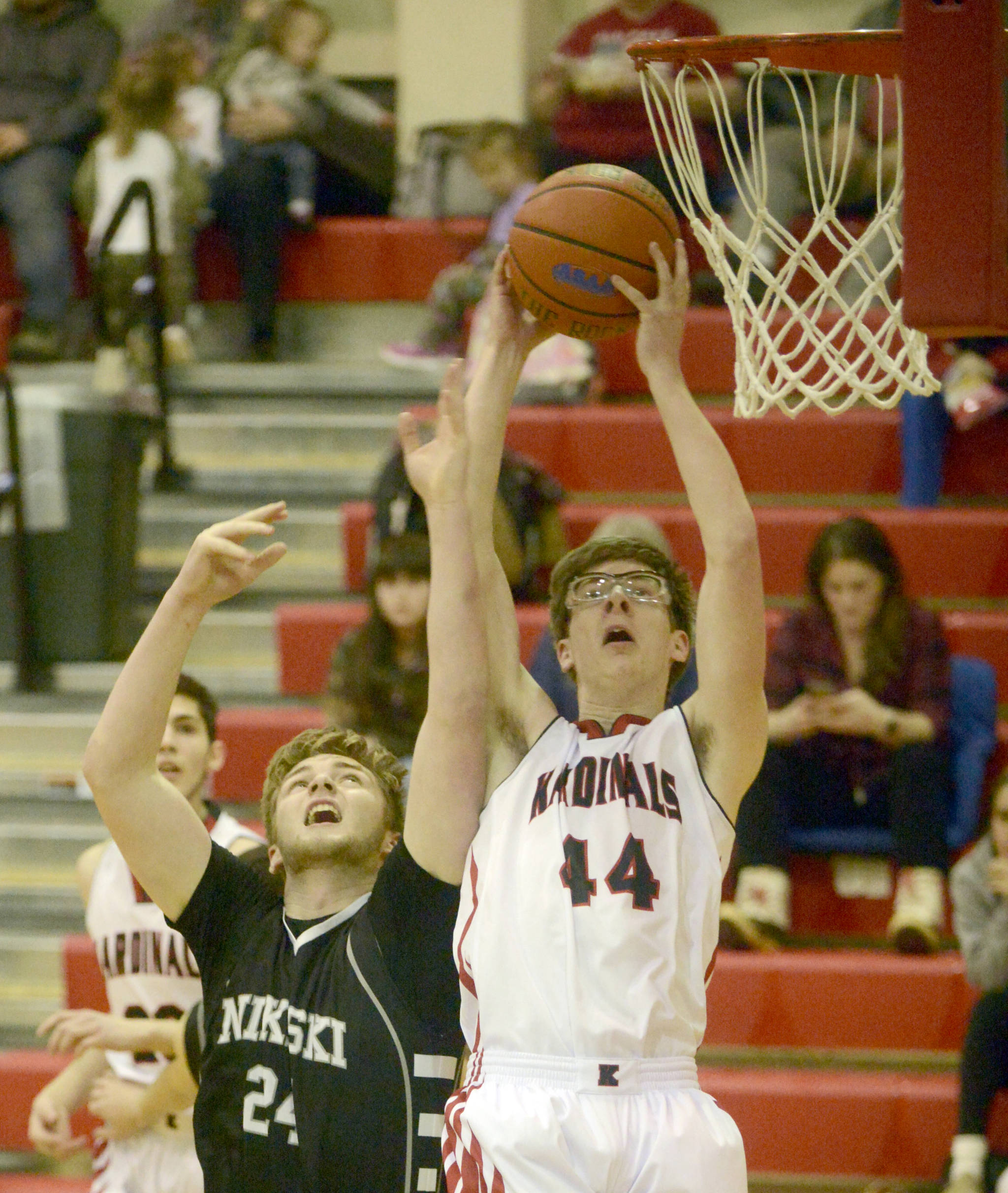 Nikiski’s Cody Handley and Kenai Central’s Kaden McKibben battle for the rebound Tuesday, Feb. 19, 2019, at Kenai Central High School. (Photo by Jeff Helminiak/Peninsula Clarion)