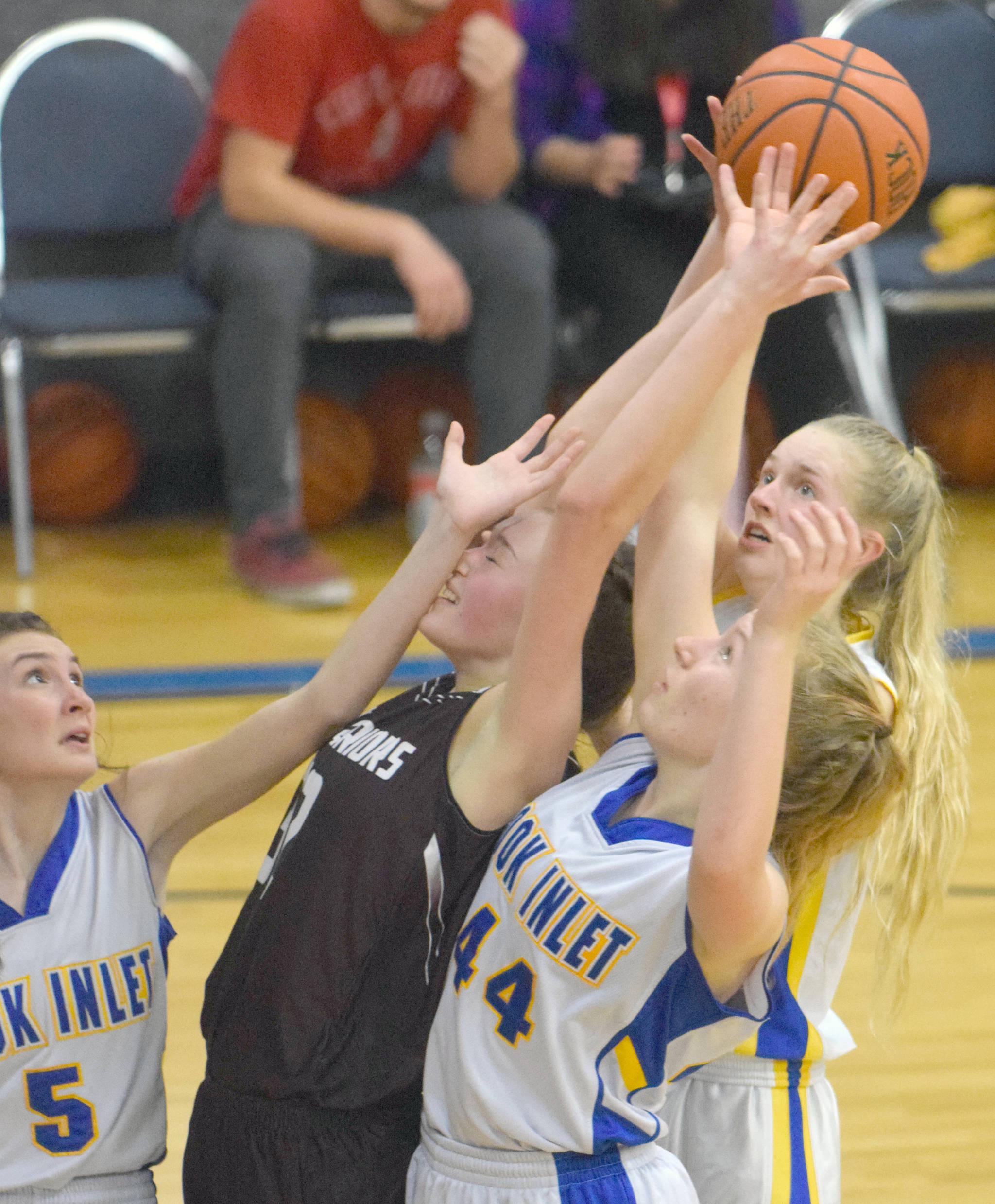 Cook Inlet Academy’s Jamie Hyatt, Adara Warren and Anna Henderson battle Nikolaevsk’s Elizabeth Fefelov for the rebound Friday, Dec. 14, 2018, at Cook Inlet Academy in Soldotna. (Photo by Jeff Helminiak/Peninsula Clarion)