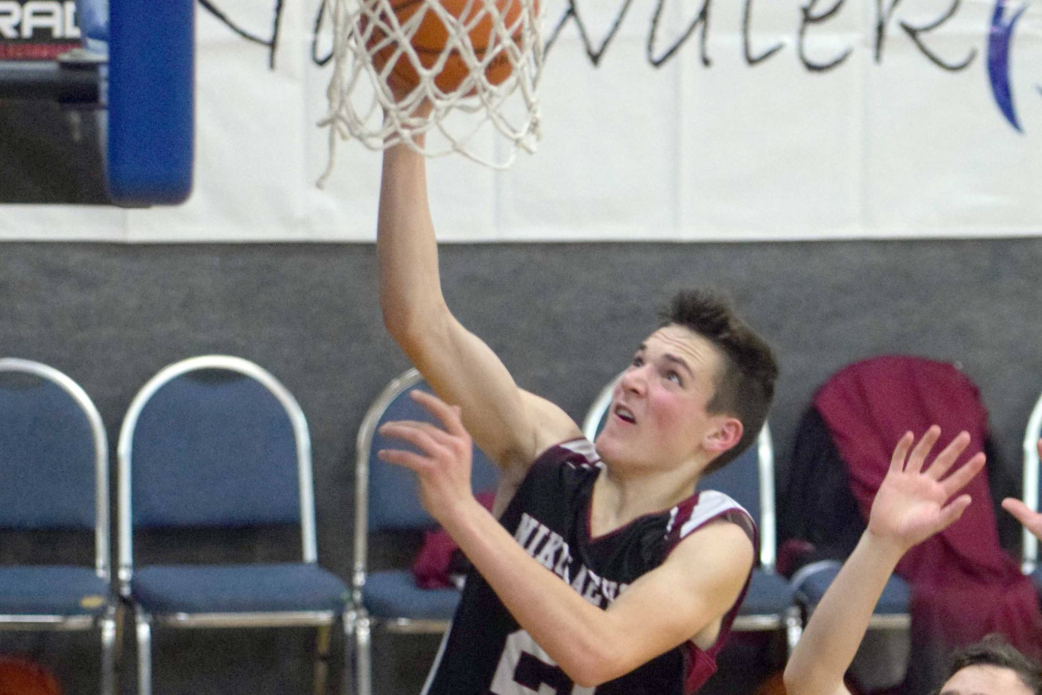 Nikolaevsk’s Justin Trail drives past Cook Inlet Academy’s James Anderson on Friday, Dec. 14, 2018, at Cook Inlet Academy in Soldotna. (Photo by Jeff Helminiak/Peninsula Clarion)