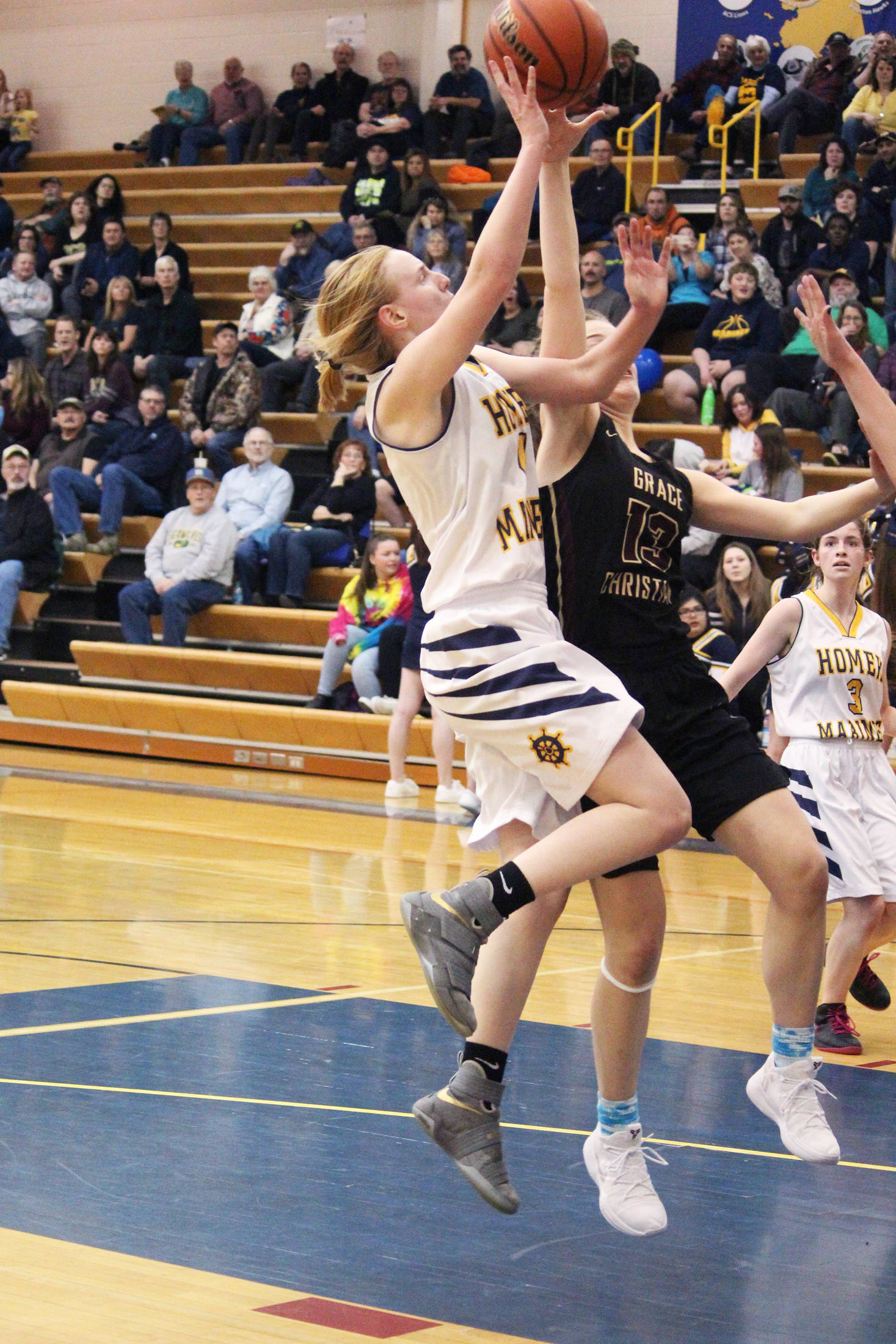 Homer’s Kelli Bishop takes a shot on the Grace Christian School basket during a Friday, Feb. 22, 2019 game in Homer, Alaska. Grace is one of three private school teams in Region 3A basketball. (Photo by Megan Pacer/Homer News)