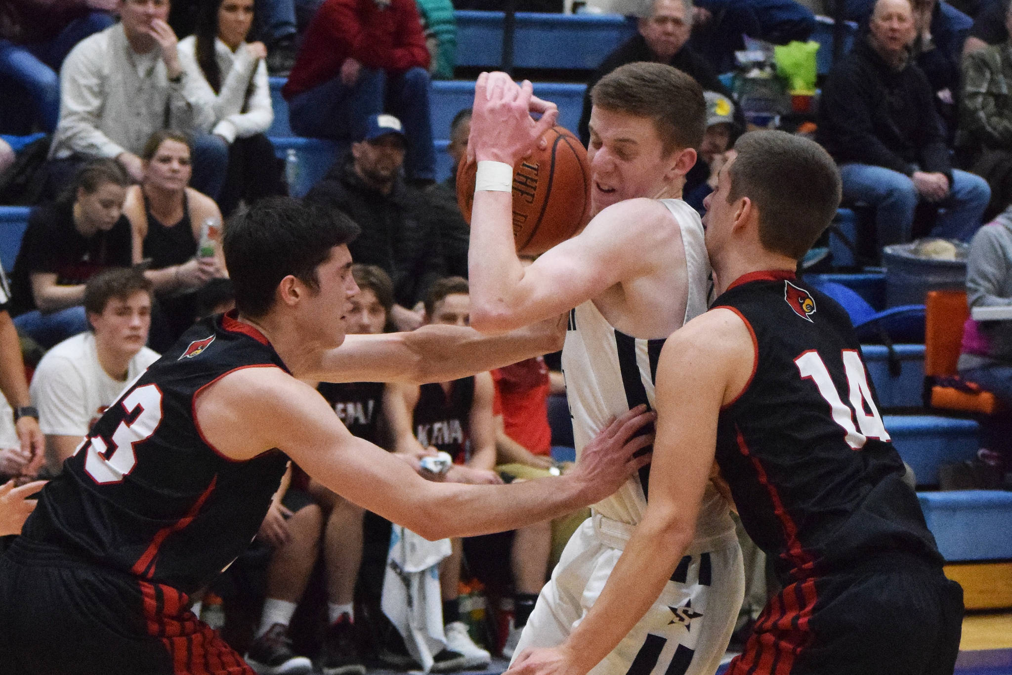 Soldotna’s Ray Chumley (middle) becomes sandwiched between Kenai’s Adam Trujillo (left) and Logan Baker Tuesday in a nonconference contest at Soldotna High School. (Photo by Joey Klecka/Peninsula Clarion)