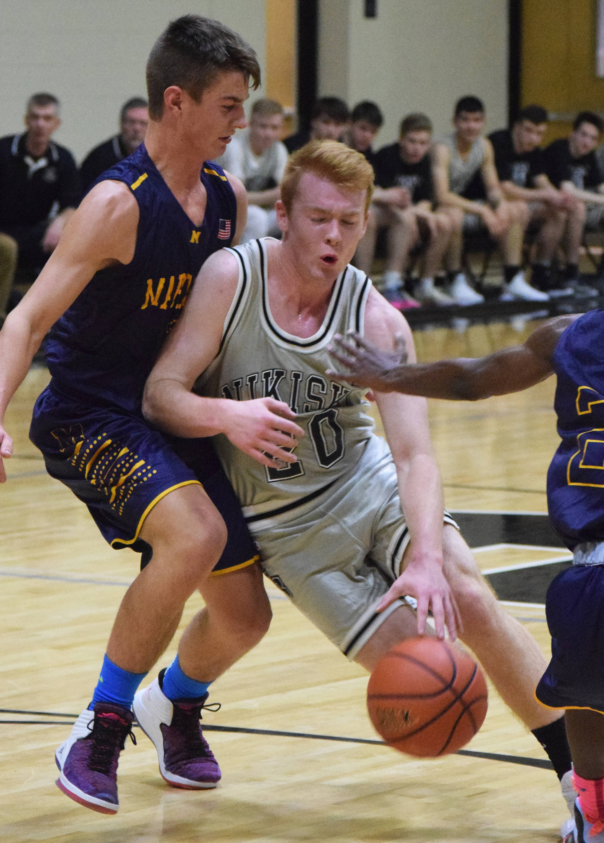 Nikiski’s Jace Kornstad (right) drives by Homer’s Clayton Beachy Friday night in a Southcentral Conference clash at Nikiski High School. (Photo by Joey Klecka/Peninsula Clarion)