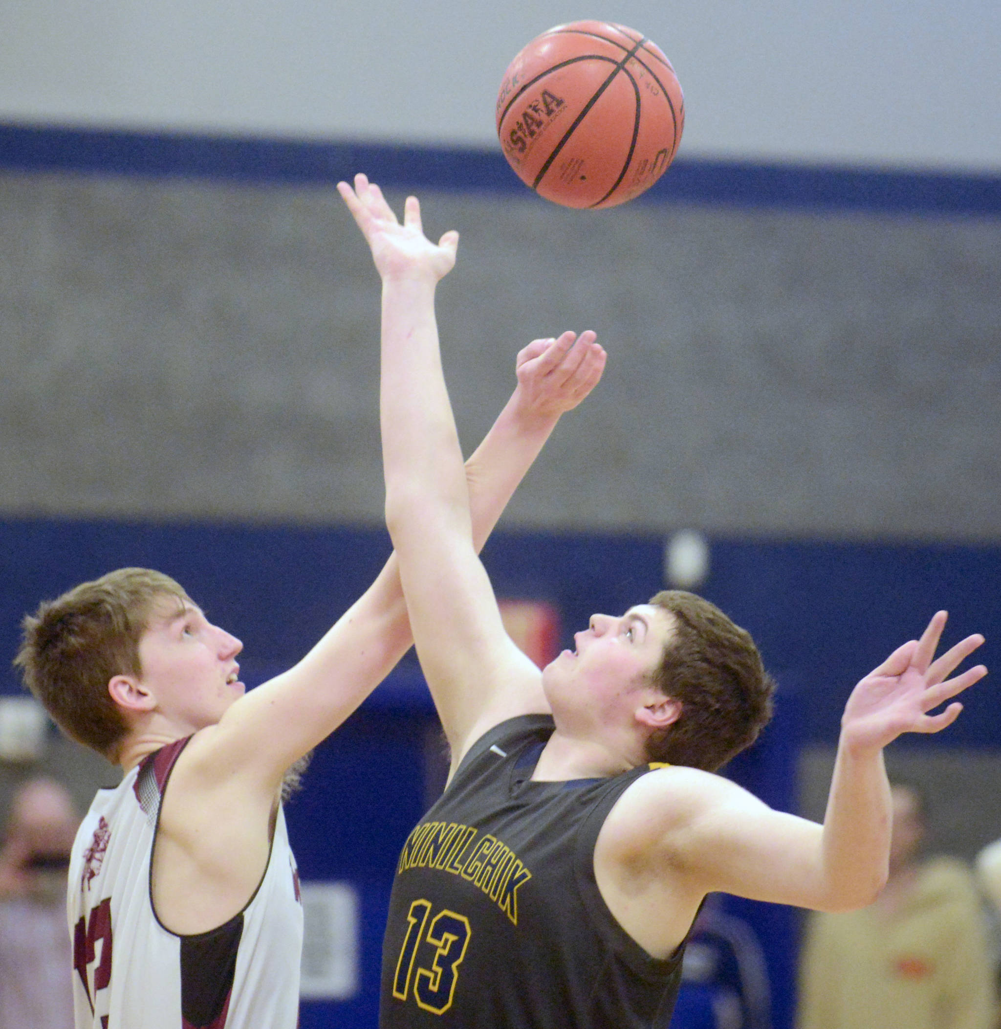 Nikolaevsk’s Kosta Nikitenko and Ninilchik’s Jake Clark battle for the opening tip Friday in the Peninsula Conference championship game at Cook Inlet Academy in Soldotna. (Photo by Jeff Helminiak/Peninsula Clarion)