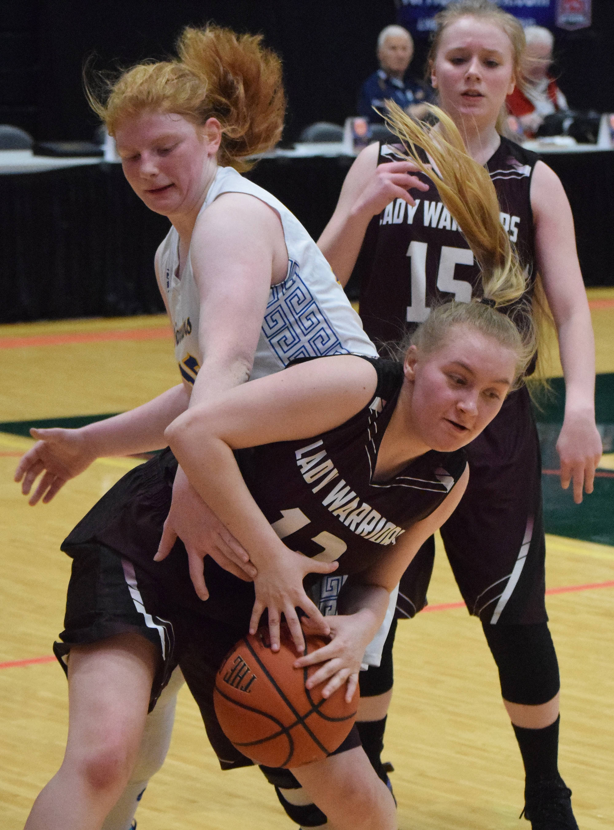 Nikolaevsk’s Kerianna Lasiter (below) beats Tri-Valley’s Victoria Pennington to a rebound Thursday at the Class 1A girls state basketball tournament in Anchorage. (Photo by Joey Klecka/Peninsula Clarion)