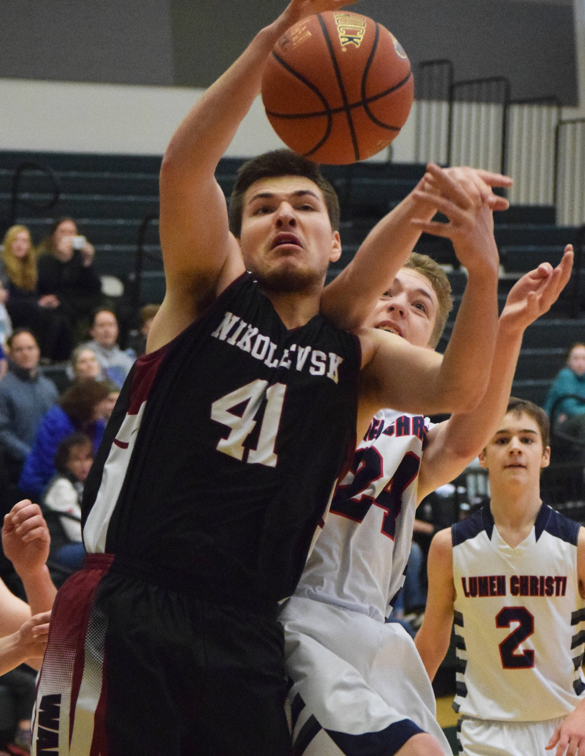 Nikolaevsk’s Michael Trail (41) grabs a rebound ahead of Lumen Christi’s Timothy Bennett Thursday at the Class 1A boys state basketball tournament in Anchorage. (Photo by Joey Klecka/Peninsula Clarion)