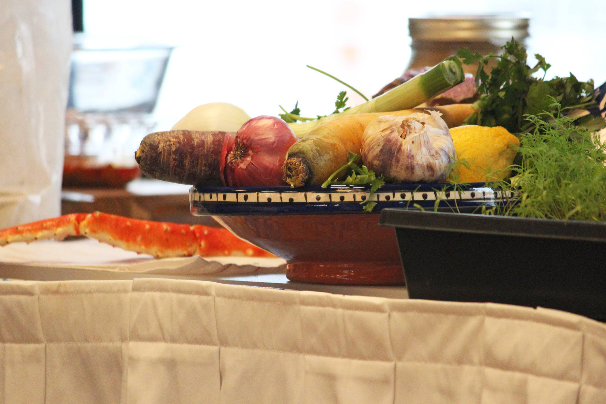 Vegetables and crab rest on a table during a cooking demo Saturday, March 9, 2019 at the Alaska Food Festival at Land’s End Resort in Homer, Alaska. (Photo by Megan Pacer/Homer News)