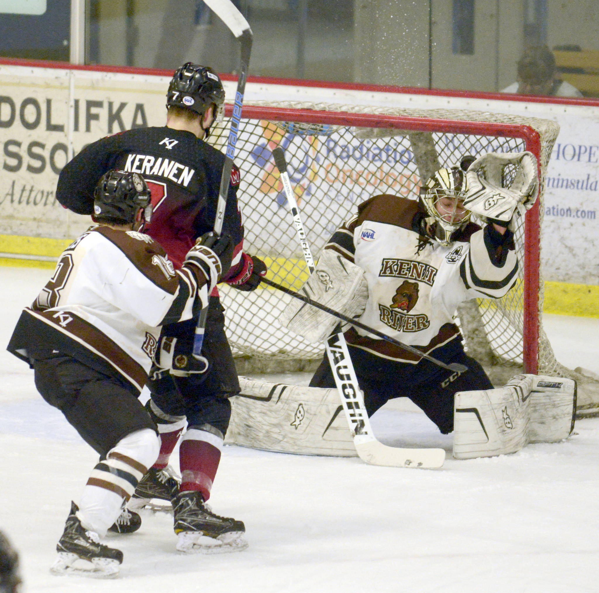 The puck squirts by the glove of Kenai River Brown Bears goaltender Gavin Enright, then goes over the goal, Thursday, March 14, night against the Minnesota Magicians at the Soldotna Regional Sports Complex. (Photo by Jeff Helminiak/Peninsula Clarion)