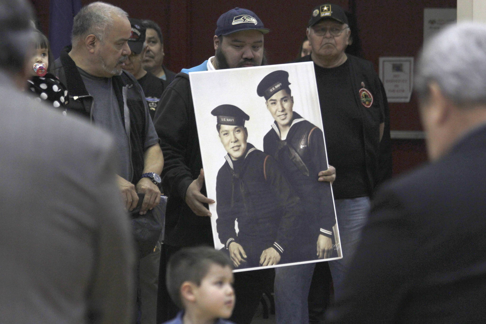 Family members of Mark and Harvey Jacobs hold a picture of the brothers during a ceremony honoring Tlingit code talkers on Monday, March 18, 2019. (Alex McCarthy | Juneau Empire)