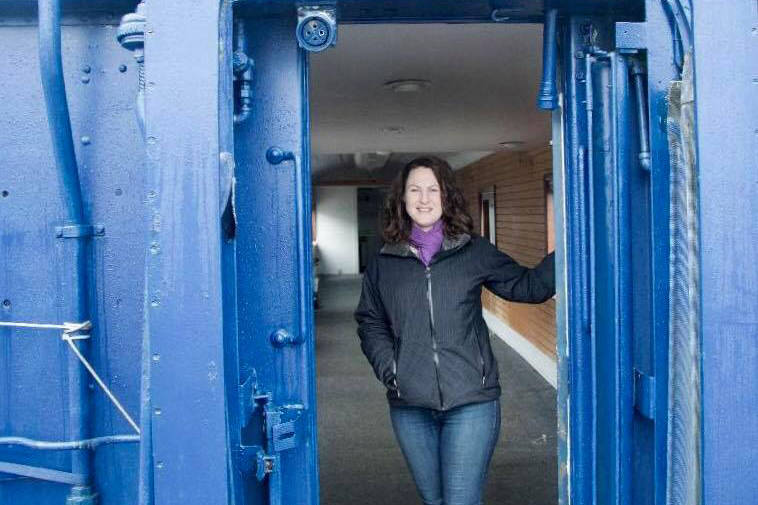 Liberty Miller stands at the end of an old Alaska Railroad train car in Seward. The train car will be the home to Miller’s new small business, 13 Ravens Coffee House. (Photo courtesy Liberty Miller)