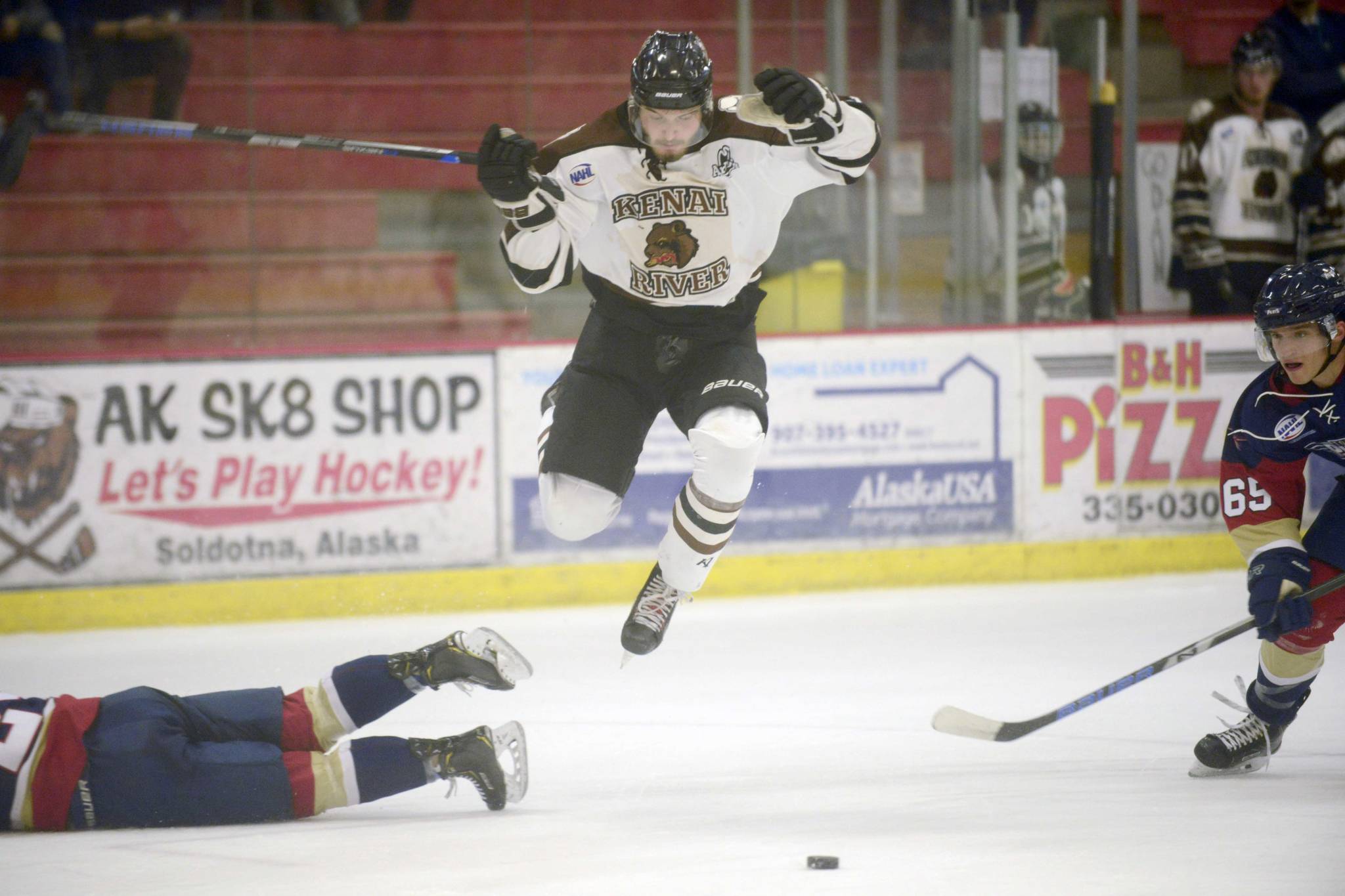 Kenai River Brown Bears forward Trey LaBarge jumps between Cole Thiessen and Shane Hathaway of the Topeka (Kansas) Pilots on Friday, Feb. 2, 2019, at the Soldotna Regional Sports Complex. (Photo by Jeff Helminiak/Peninsula Clarion)