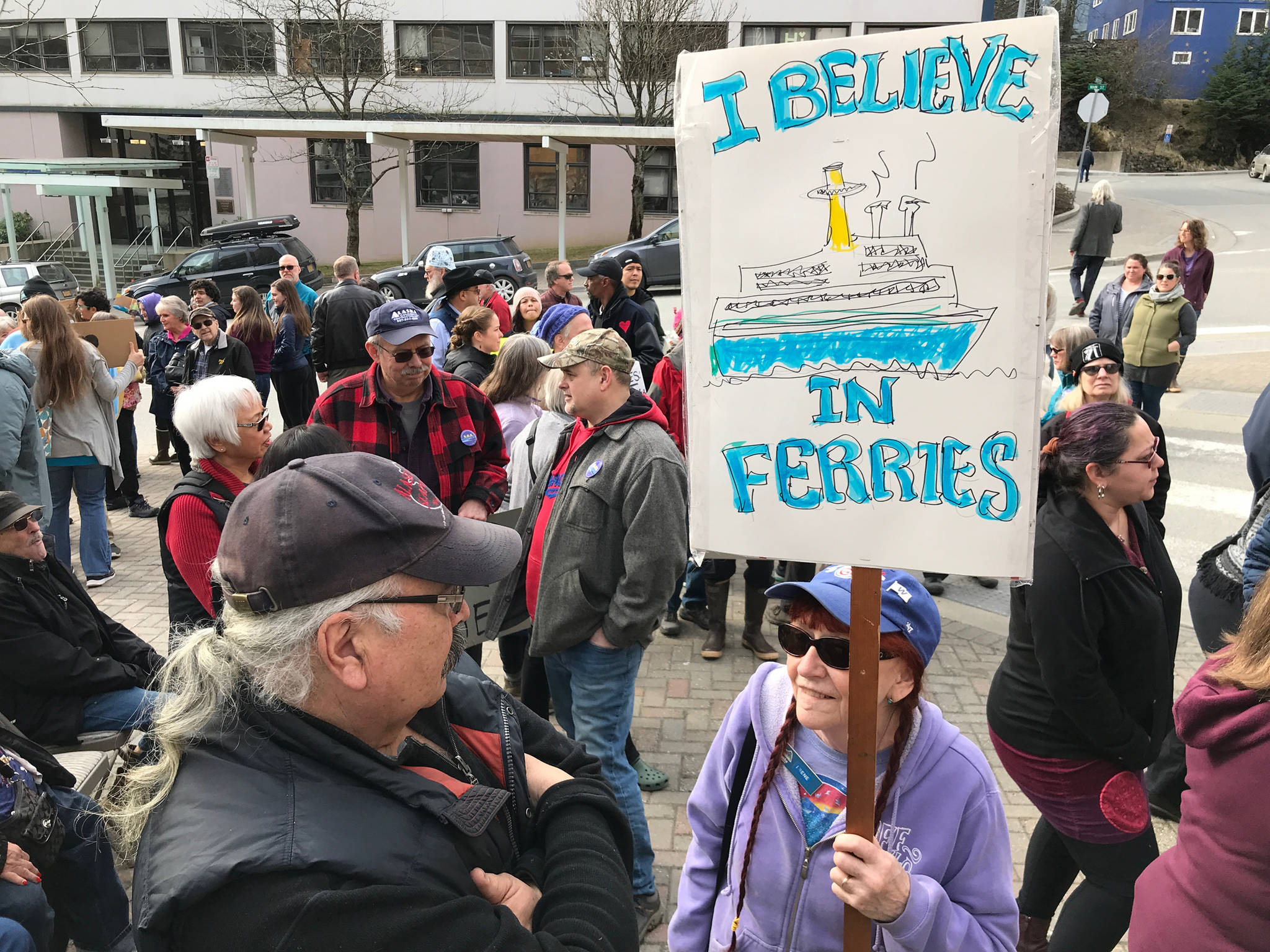 Irene Morris, with her sign, attends the Alaska Public Employees Association’s Save the Alaska Marine Highway System rally in front of the Capitol on Wednesday, March 20, 2019. (Michael Penn | Juneau Empire)