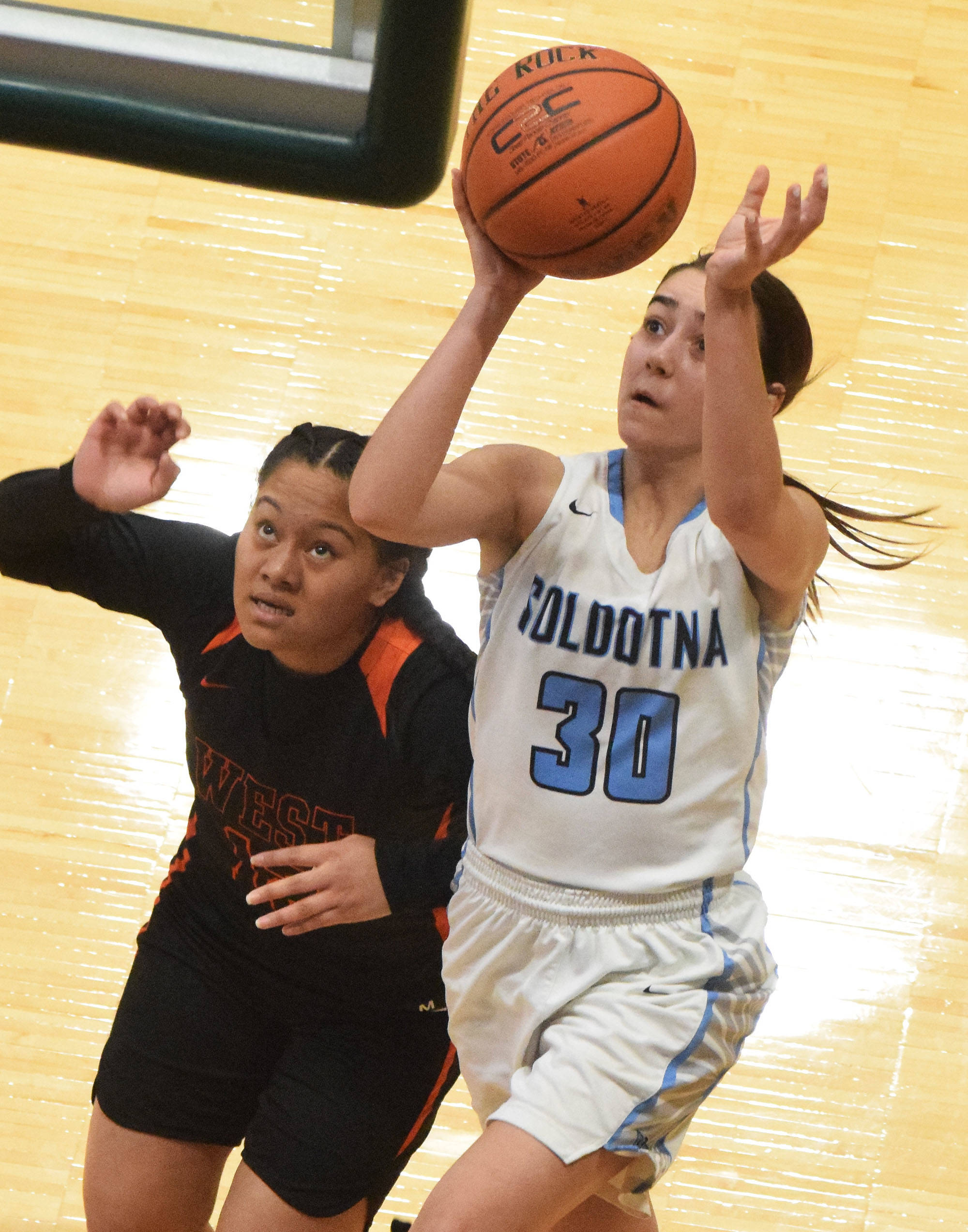 Soldotna’s Drysta Crosby-Schneider (30) lays in a bucket over a West defender Thursday, Mar. 21, 2019, at the Class 4A state championship tournament at the Alaska Airlines Center in Anchorage. (Photo by Joey Klecka/Peninsula Clarion)