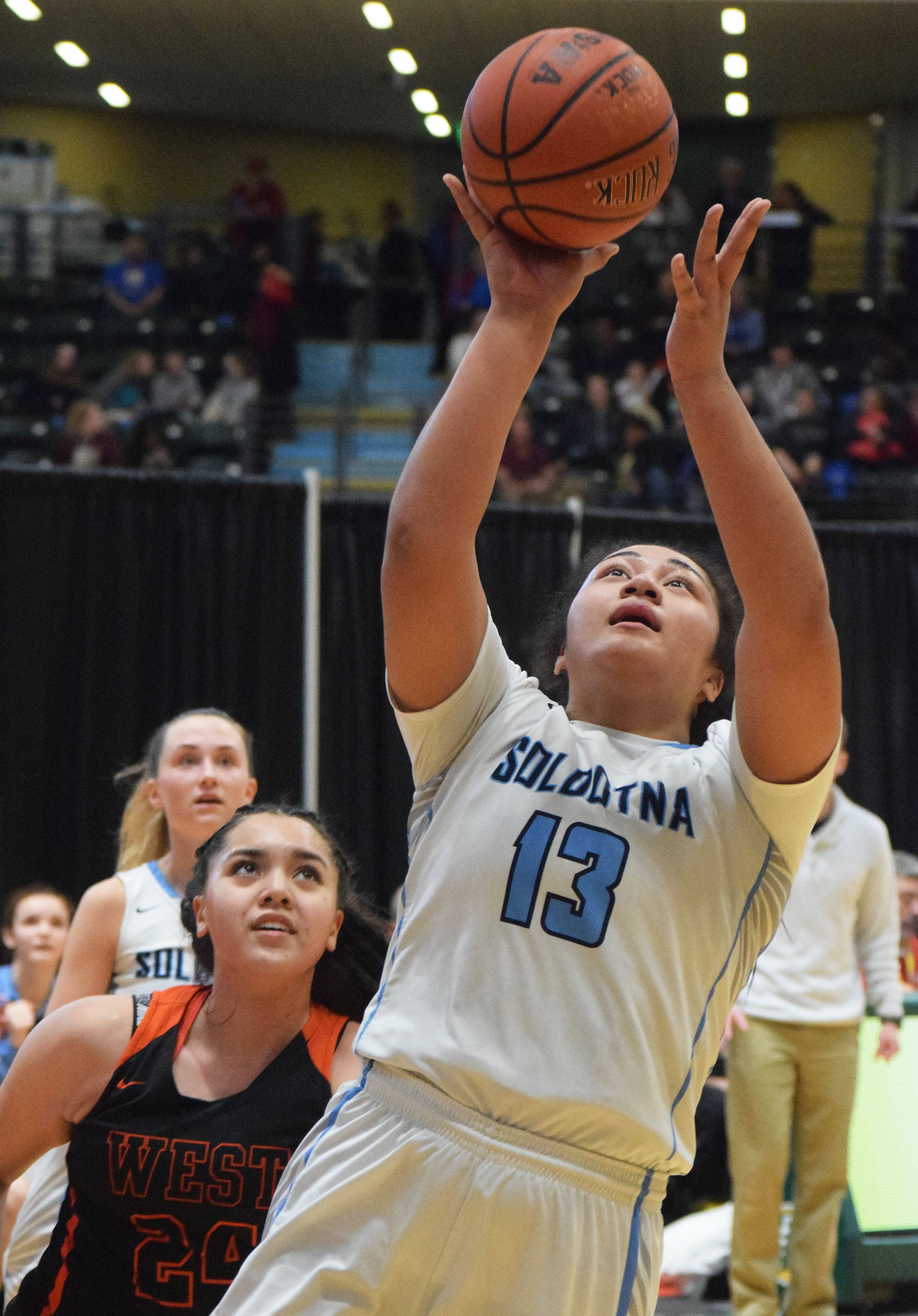 Soldotna’s Ituau Tuisaula (13) puts up a shot over West’s Juliette Adlawan, Thursday, Mar. 21, 2019, at the Class 4A state championship tournament at the Alaska Airlines Center in Anchorage. (Photo by Joey Klecka/Peninsula Clarion)