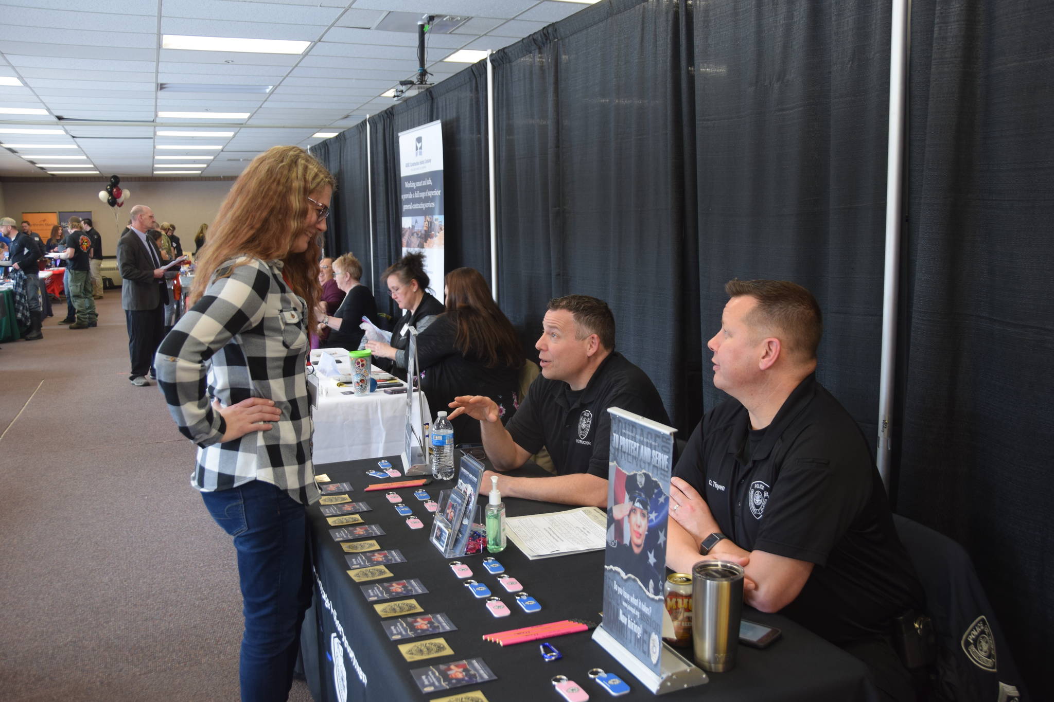 Sgt. Mike Jensen from the Anchorage Police Department talks to a participant of the Peninsula Job Fair at the Soldotna Regional Sports Complex in Soldotna, Alaska, on March 21, 2019. (Photo by Brian Mazurek/Peninsula Clarion)